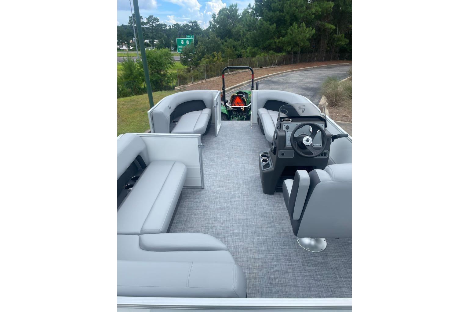 2026 Sun Tracker Party Barge 16 DLX interior with gray seating and steering console.