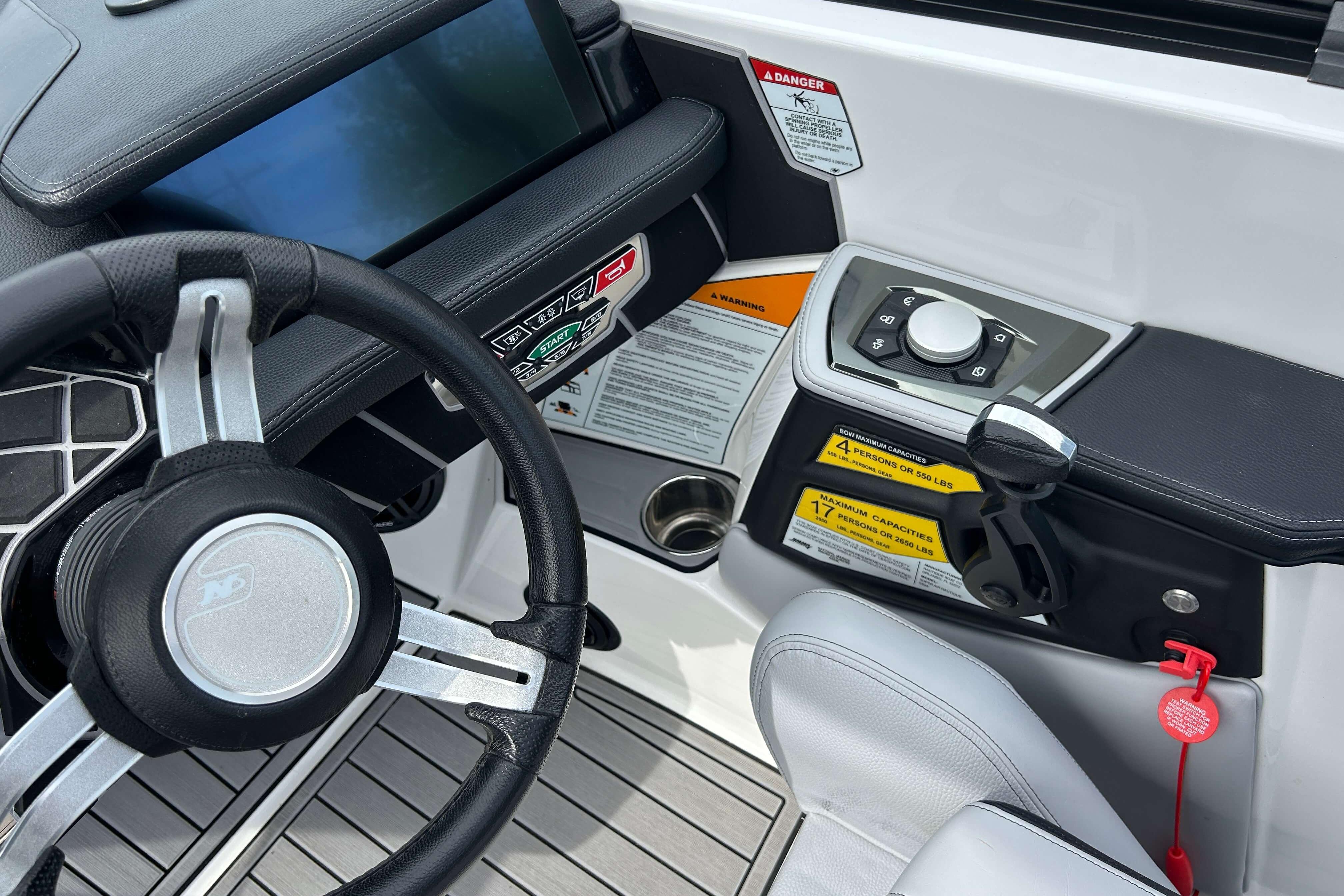 2021 Nautique Super Air Nautique GS24 dashboard with steering wheel and control panel.