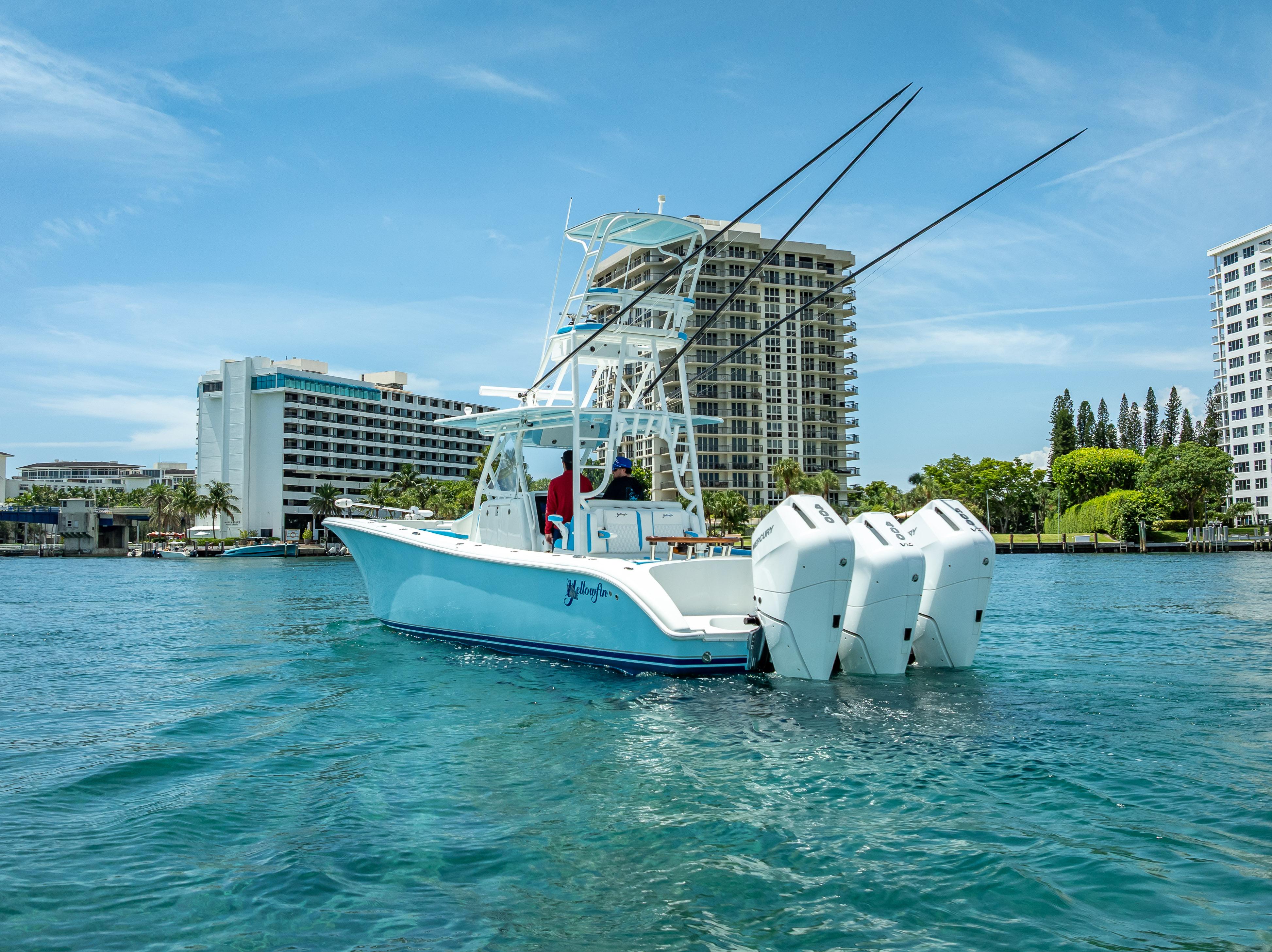 2016 Yellowfin 39 Offshore boat with triple engines on clear water near urban buildings.