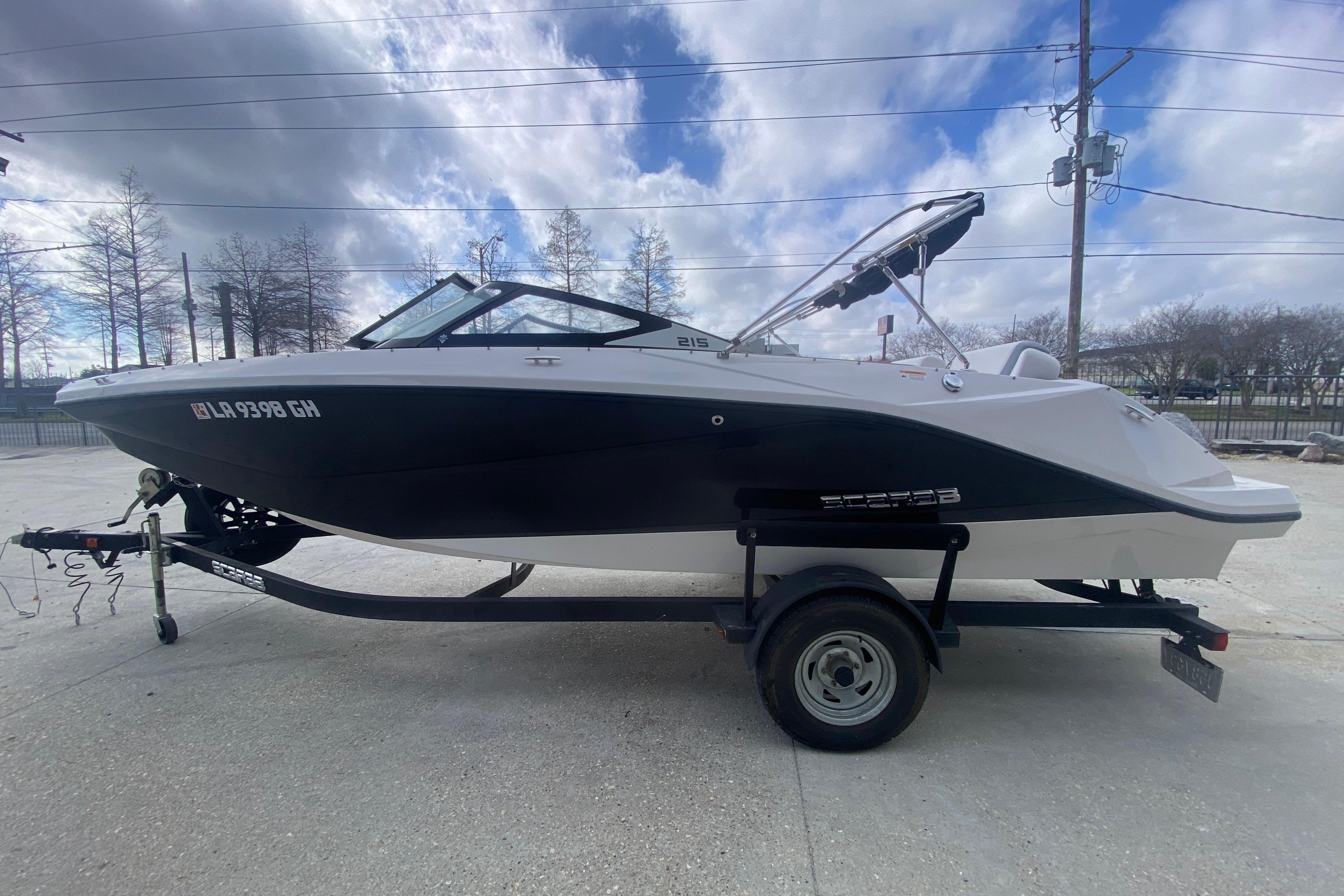 2018 Scarab 215 G boat on trailer under cloudy sky.