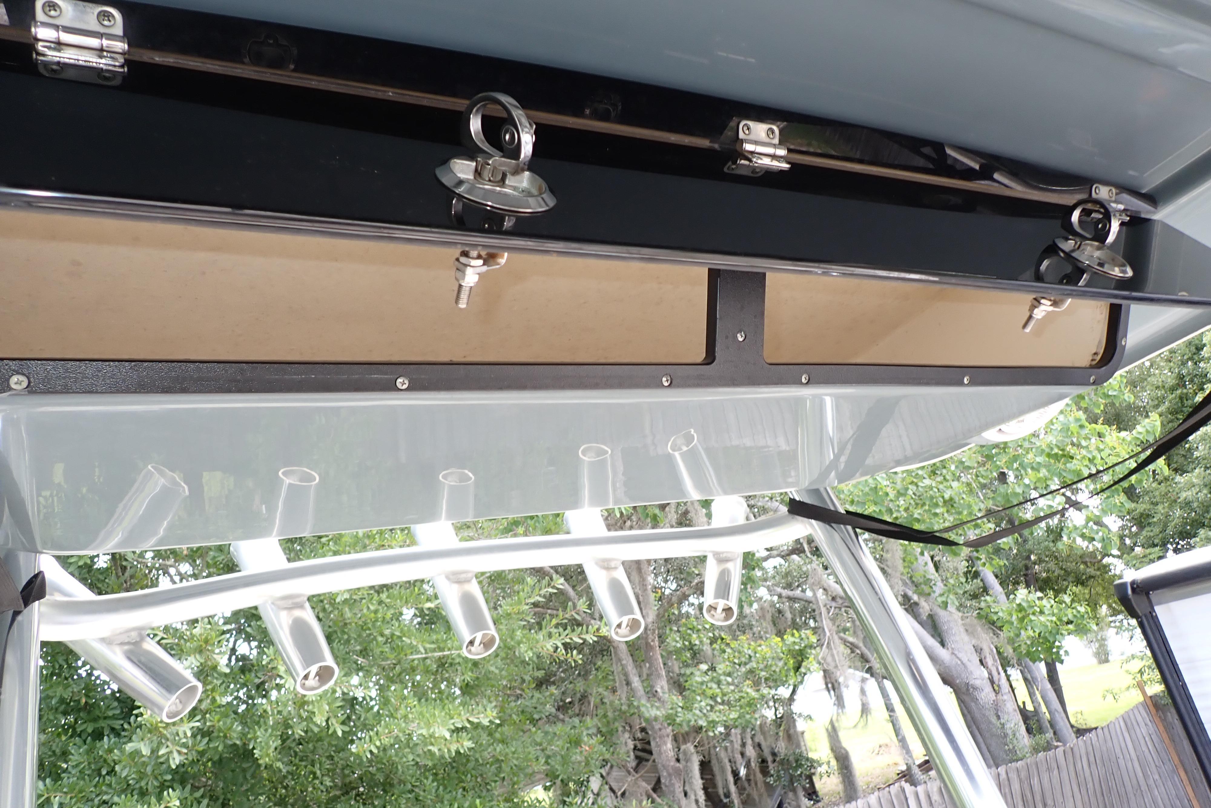 2019 Key West 263 FS boat storage compartments and rod holders, with lush greenery in the background.