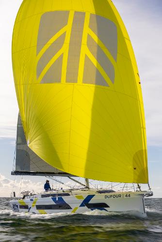 Dufour 44 sailboat model with vibrant yellow sail on open water.