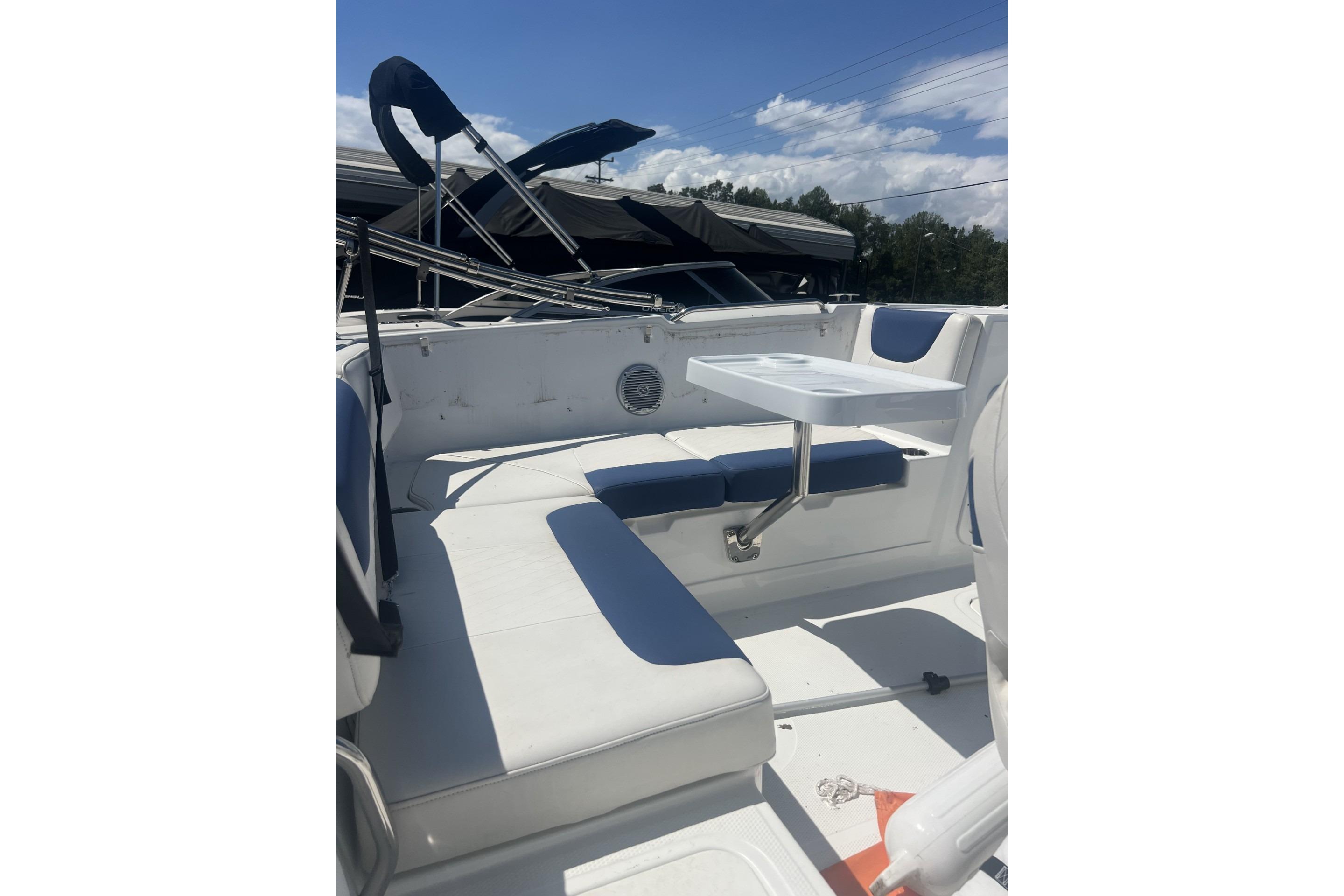 2017 Tahoe 2150 boat interior with white seating and a small table.