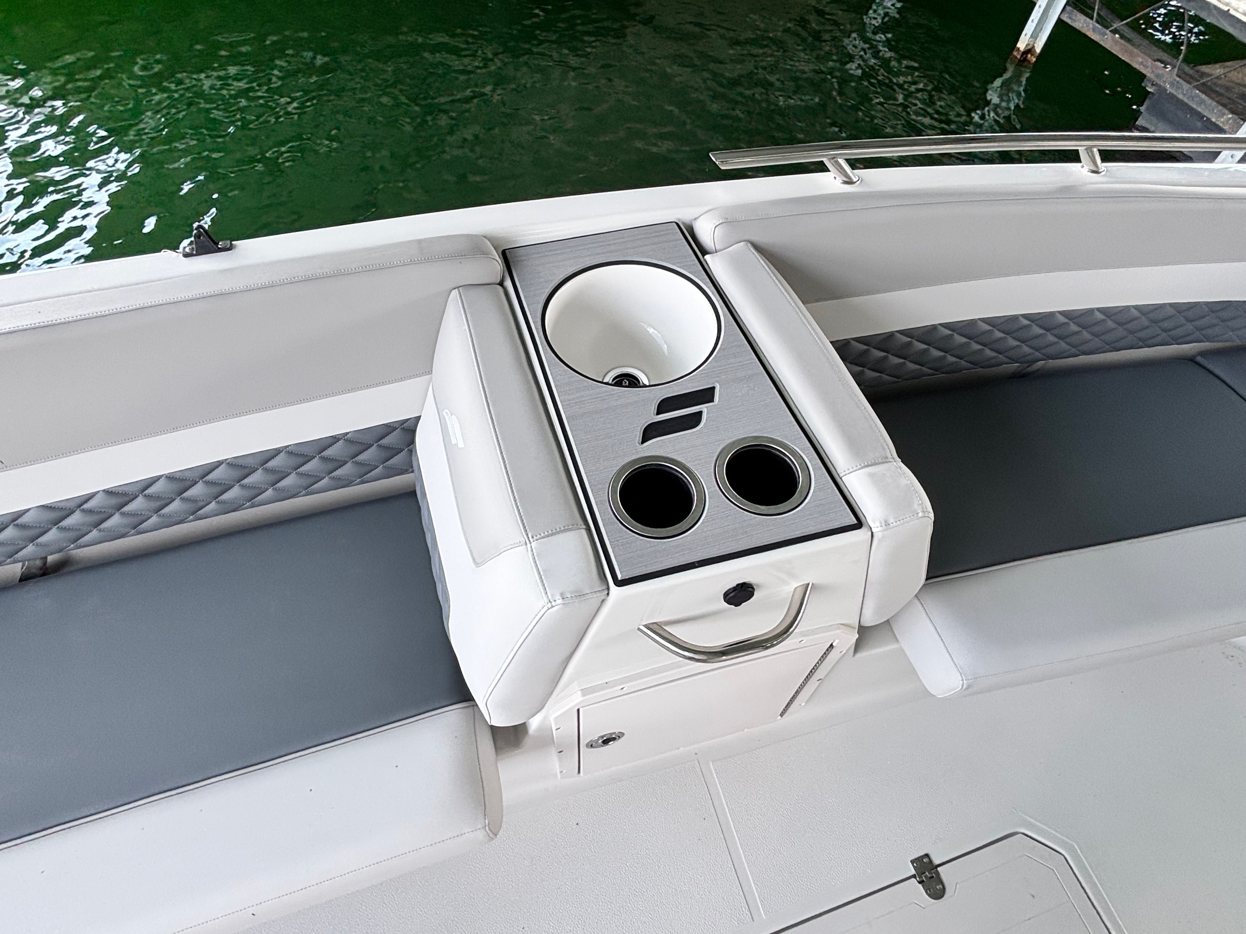 The image shows the cockpit of a Starcraft 211SVXOB boat with a sink and cup holders.