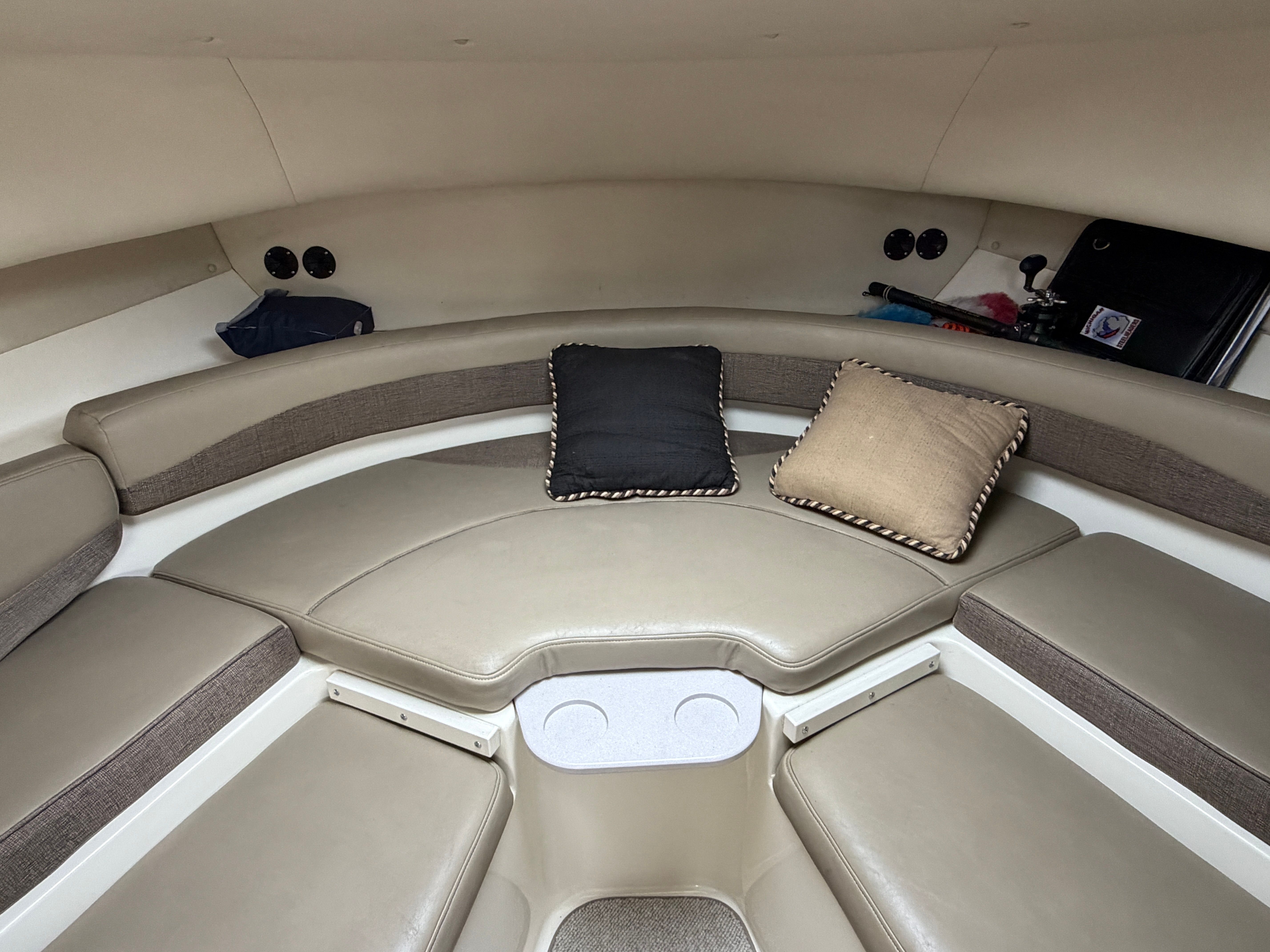 Interior of a 2001 Boston Whaler 26 Conquest with cushioned seating and pillows.