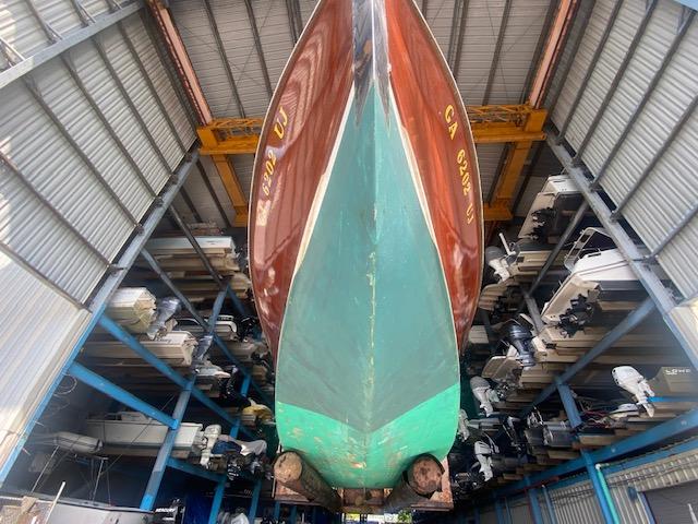 Grand Craft Classic Runabout 2000 stored in a boat warehouse, viewed from below.