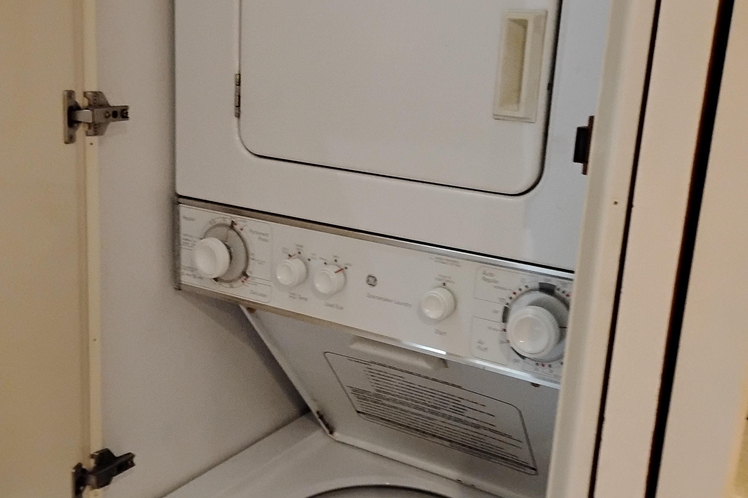 Laundry unit inside 1995 Queenship 62 Pilothouse Motor Yacht, featuring stacked washer and dryer.