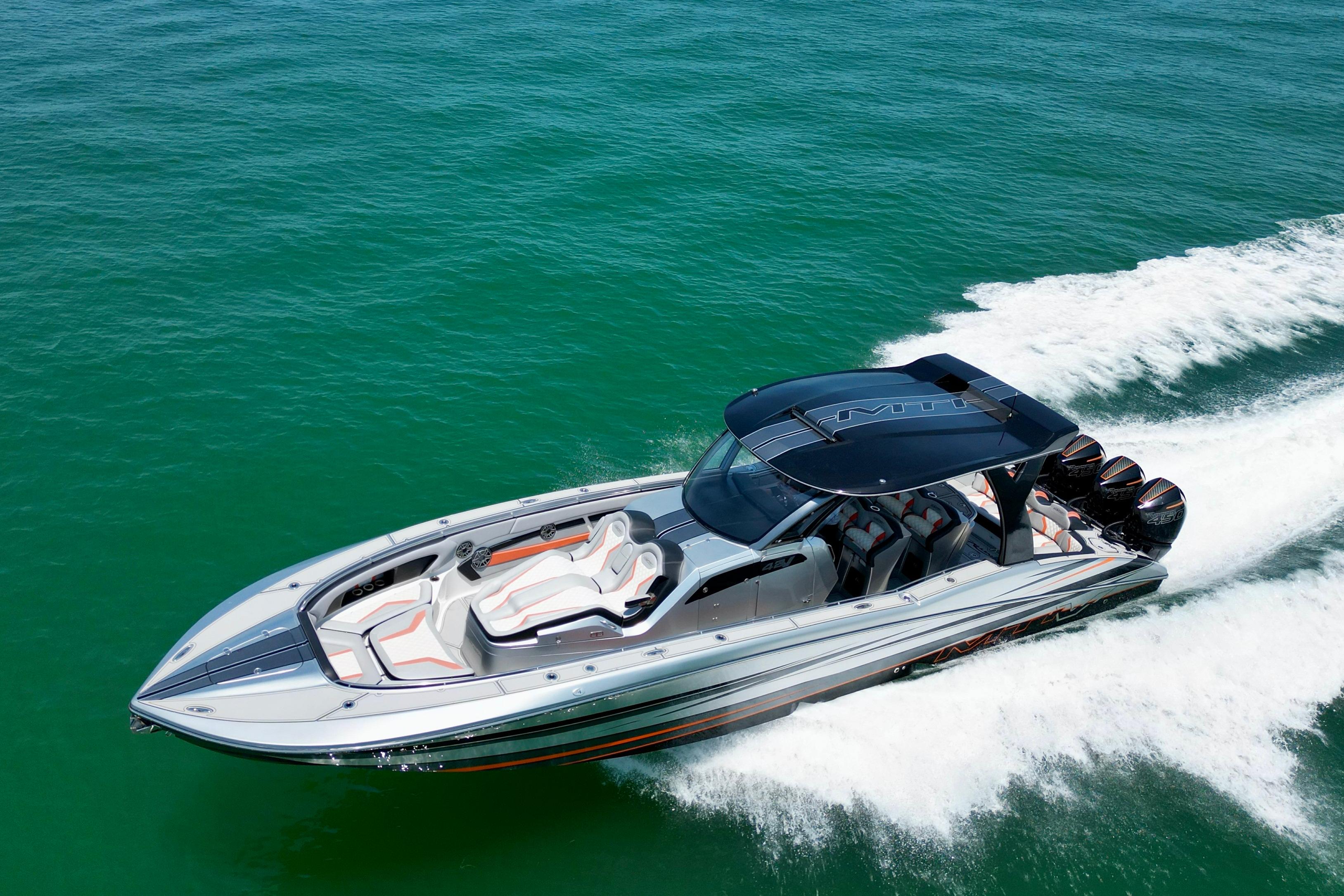 High-performance 2017 MTI V42 speedboat cruising on clear turquoise waters.