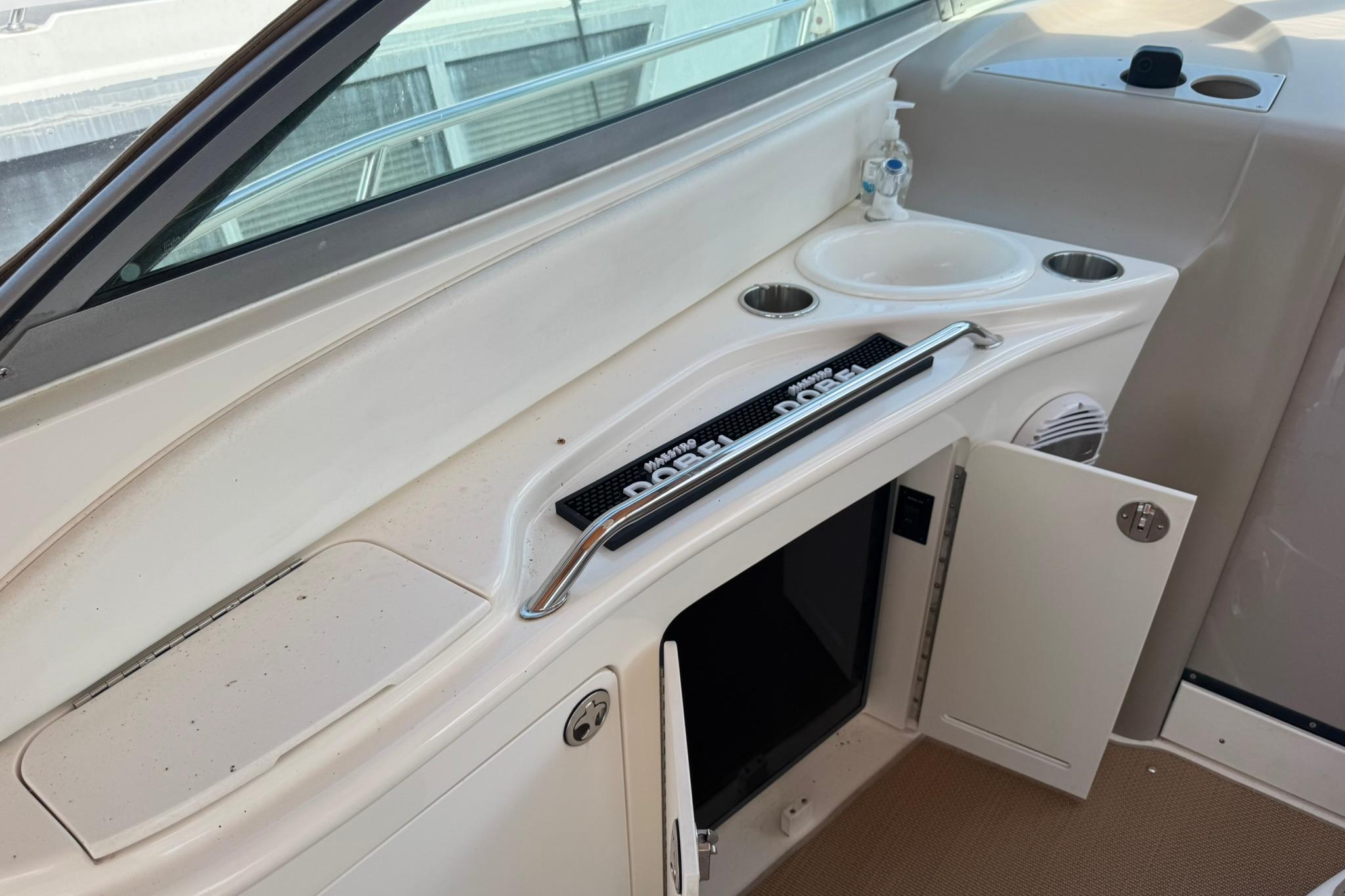 2001 Sea Ray 340 Sundancer boat interior with sink, storage, and cup holders.