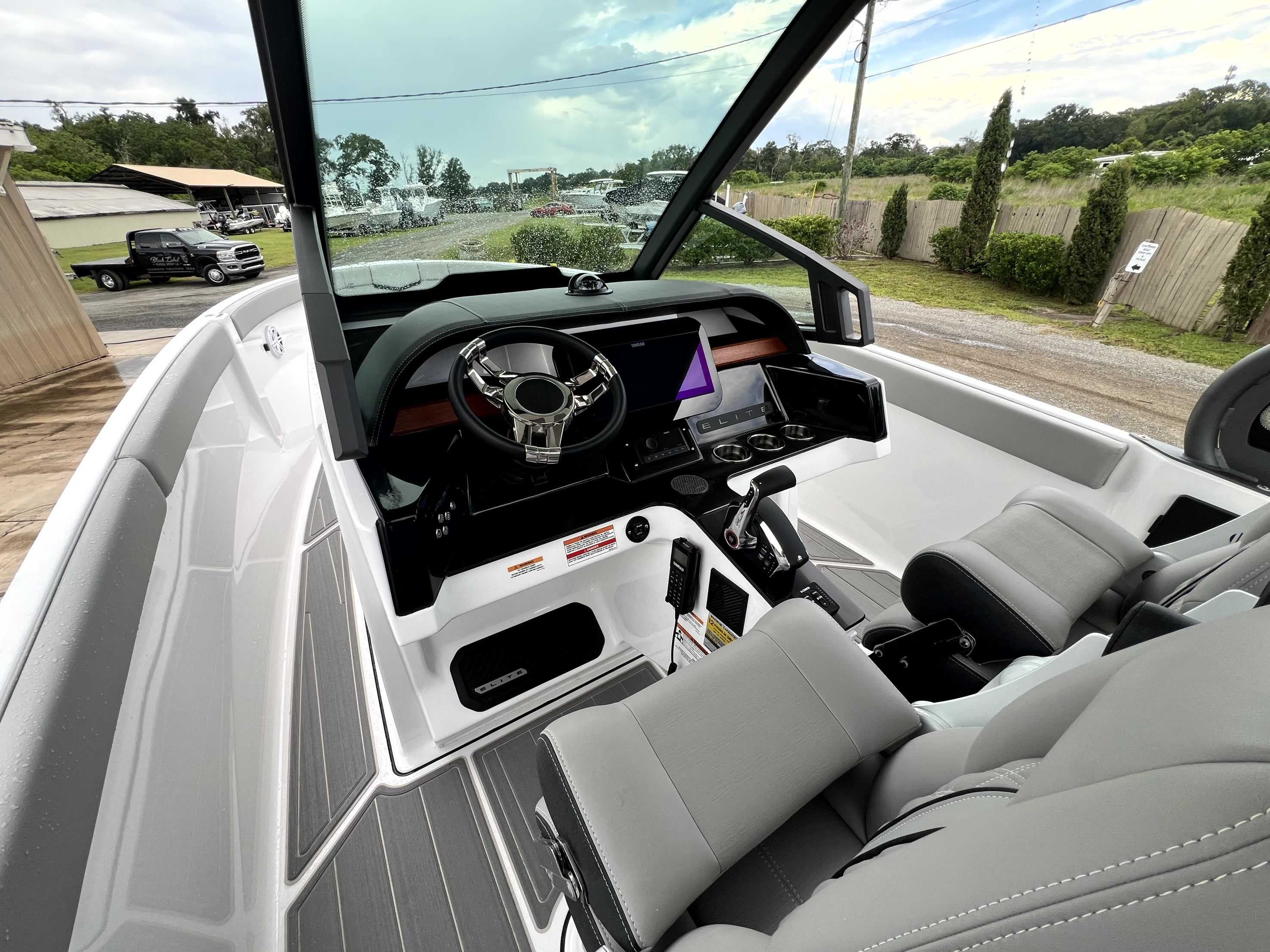 The image shows the cockpit of a Monterey Elite 25 boat with modern instruments and gray seats.
