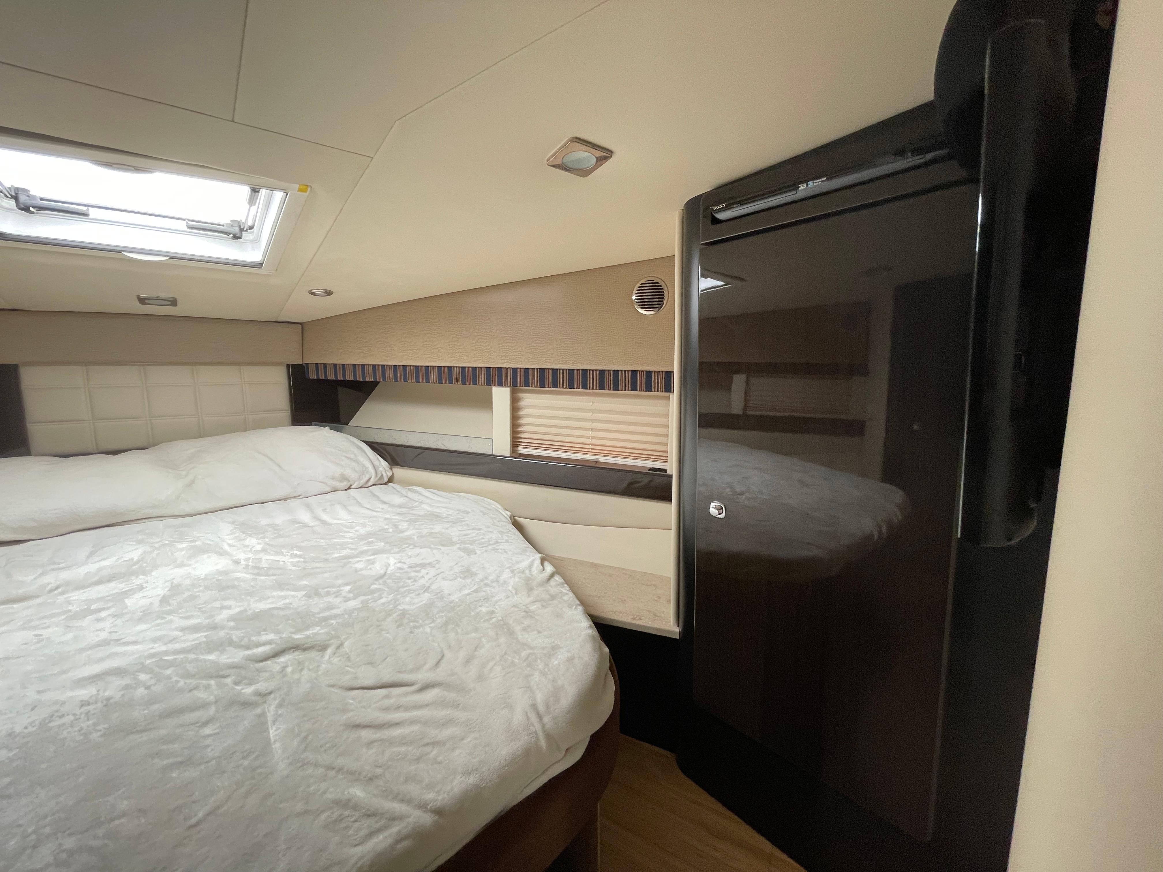 2014 Formula 45 Yacht bedroom with bed, skylight, and sleek cabinetry.