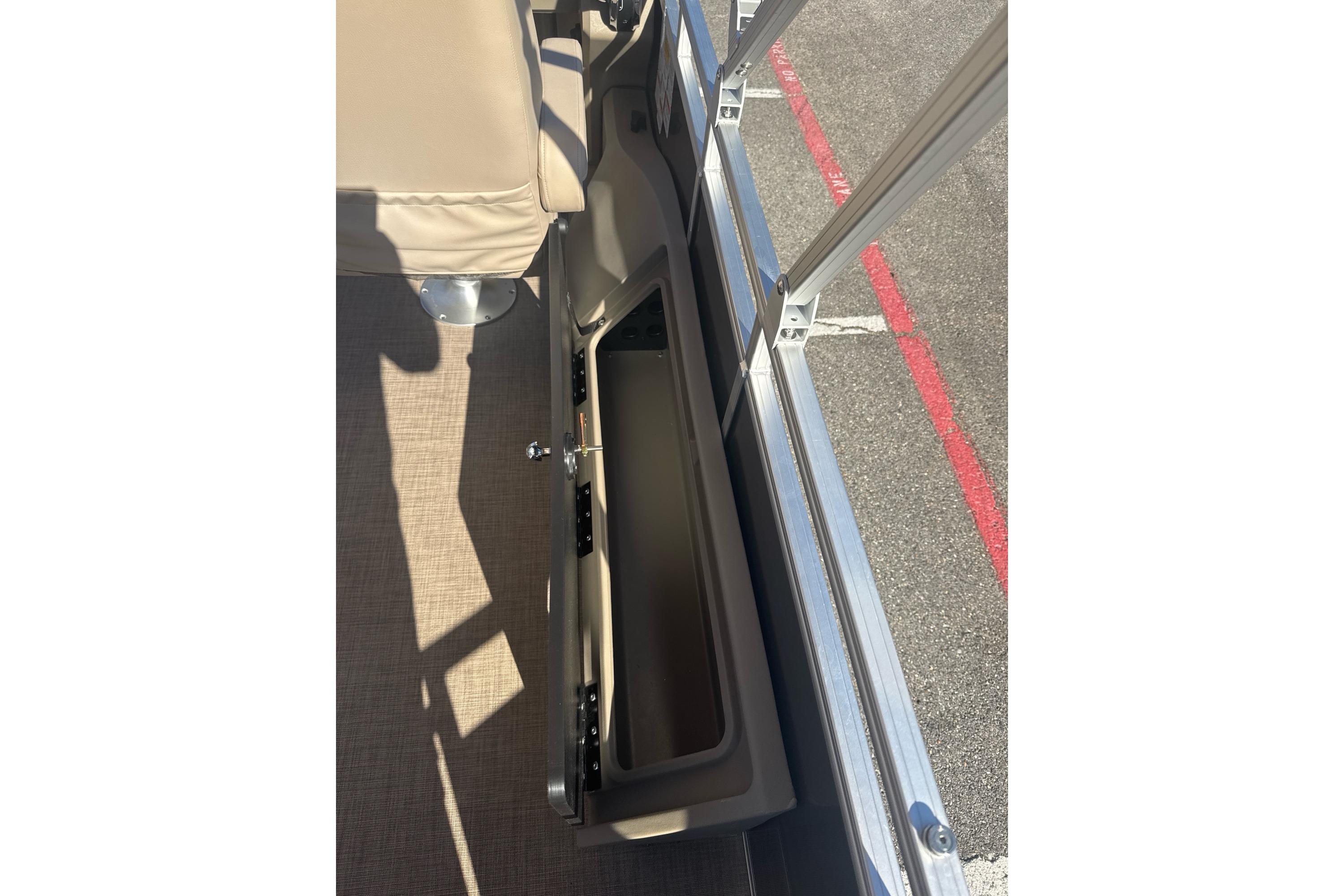 2025 Sun Tracker SportFish 22 DLX interior storage compartment with beige seating.