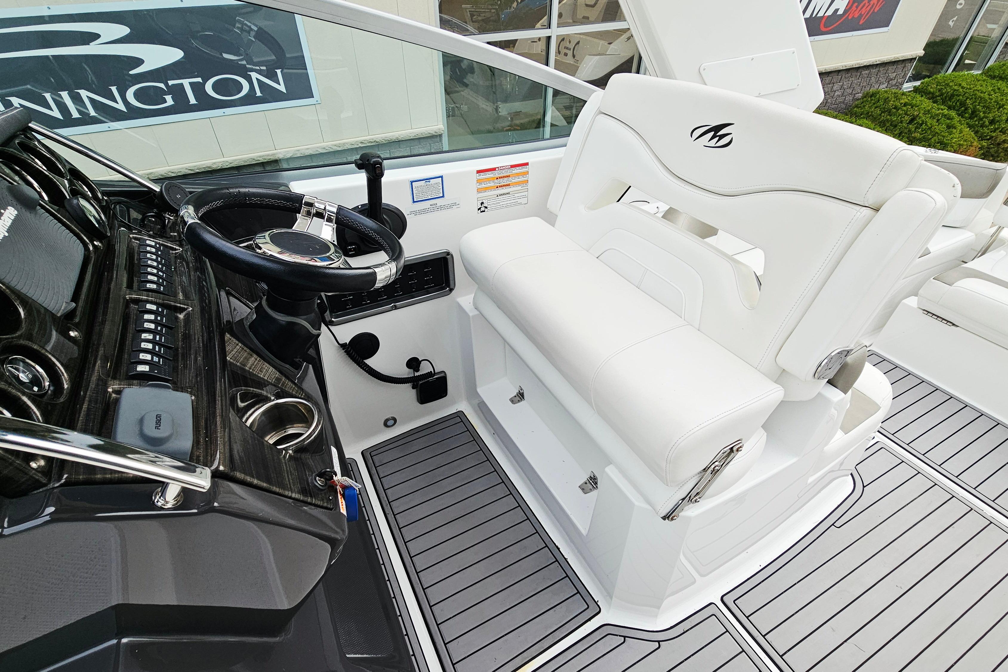 Helm of 2016 Monterey 295 Sport Yacht with white seating and sleek dashboard controls.