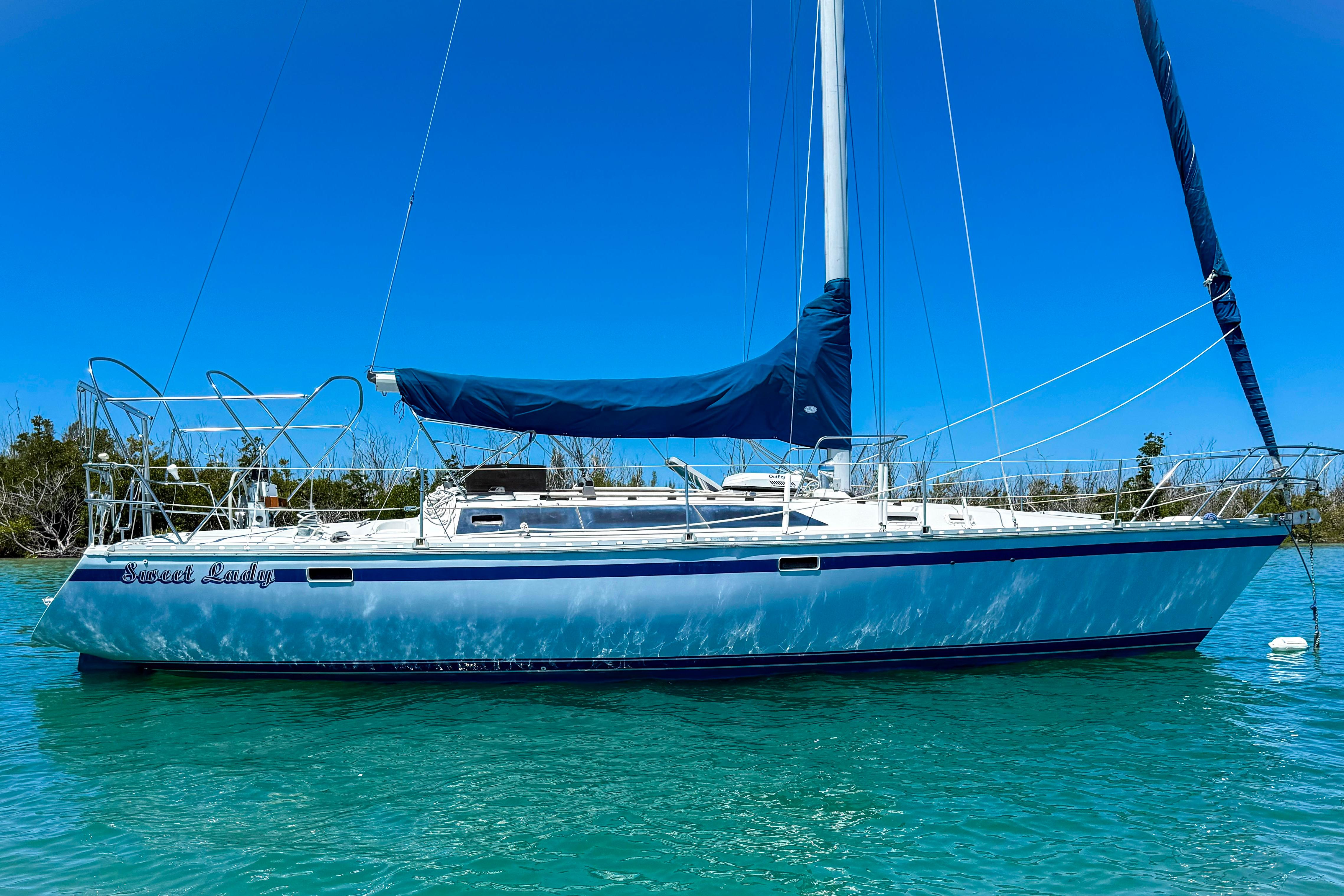 1988 Oday 40 sailboat on clear blue water under a bright sky.