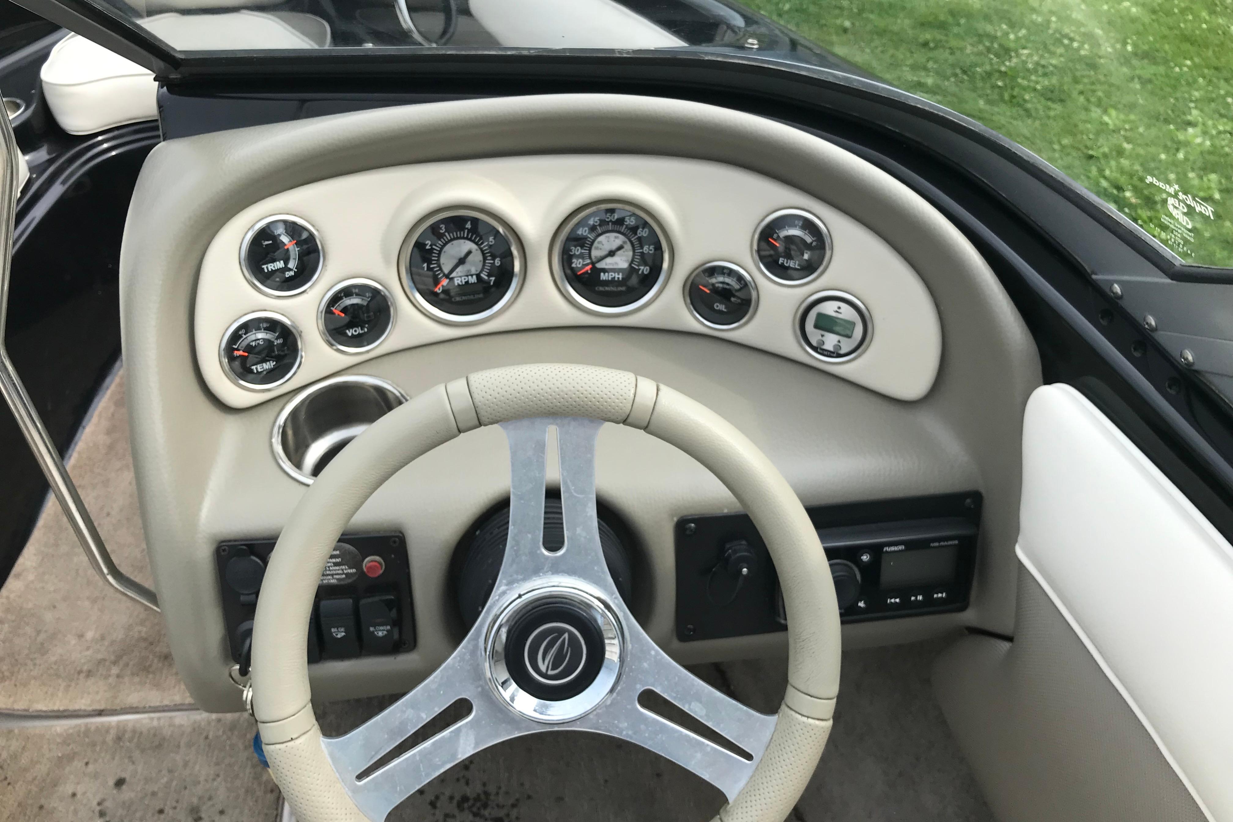 Dashboard of a 2015 Crownline 18 SS boat with gauges and steering wheel.