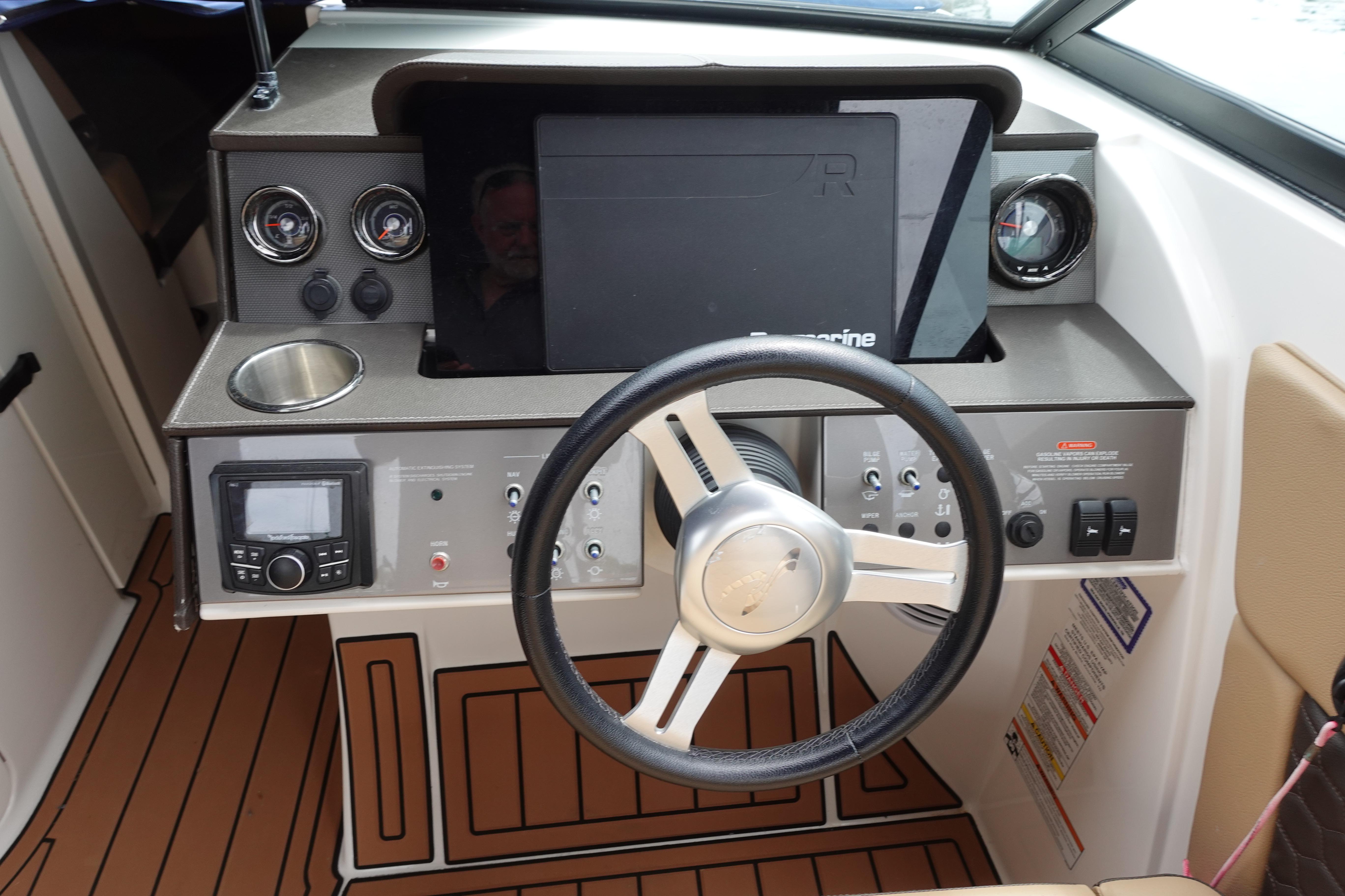 Cockpit of 2018 Sea Ray SDX 270 boat with steering wheel and control panel.