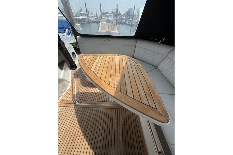 2021 Sea Ray Sundancer 320 Outboard interior with elegant wooden table and seating area.
