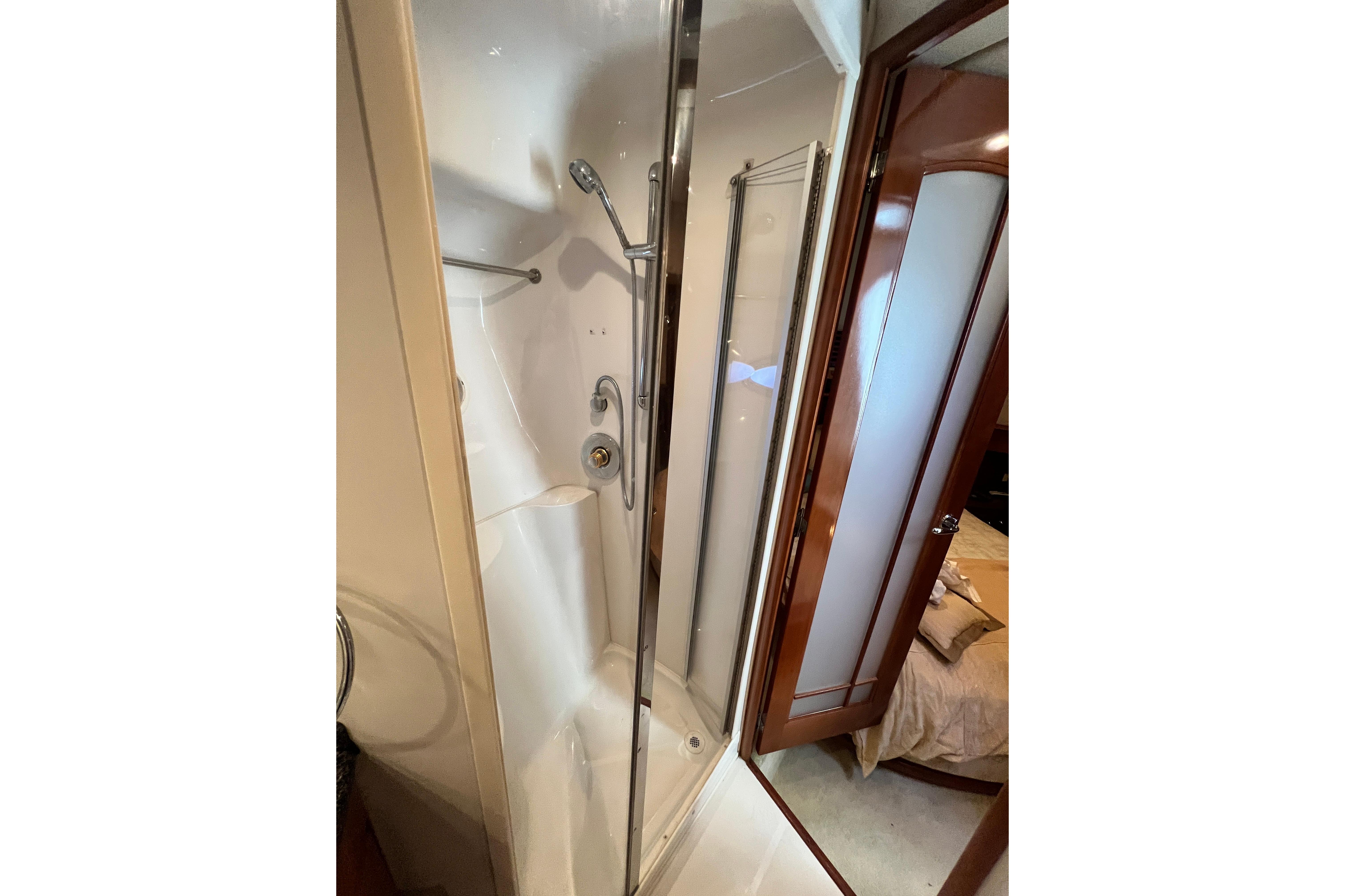 Shower area in 2003 Carver 450 Voyager Pilothouse yacht, featuring glass door and modern fixtures.