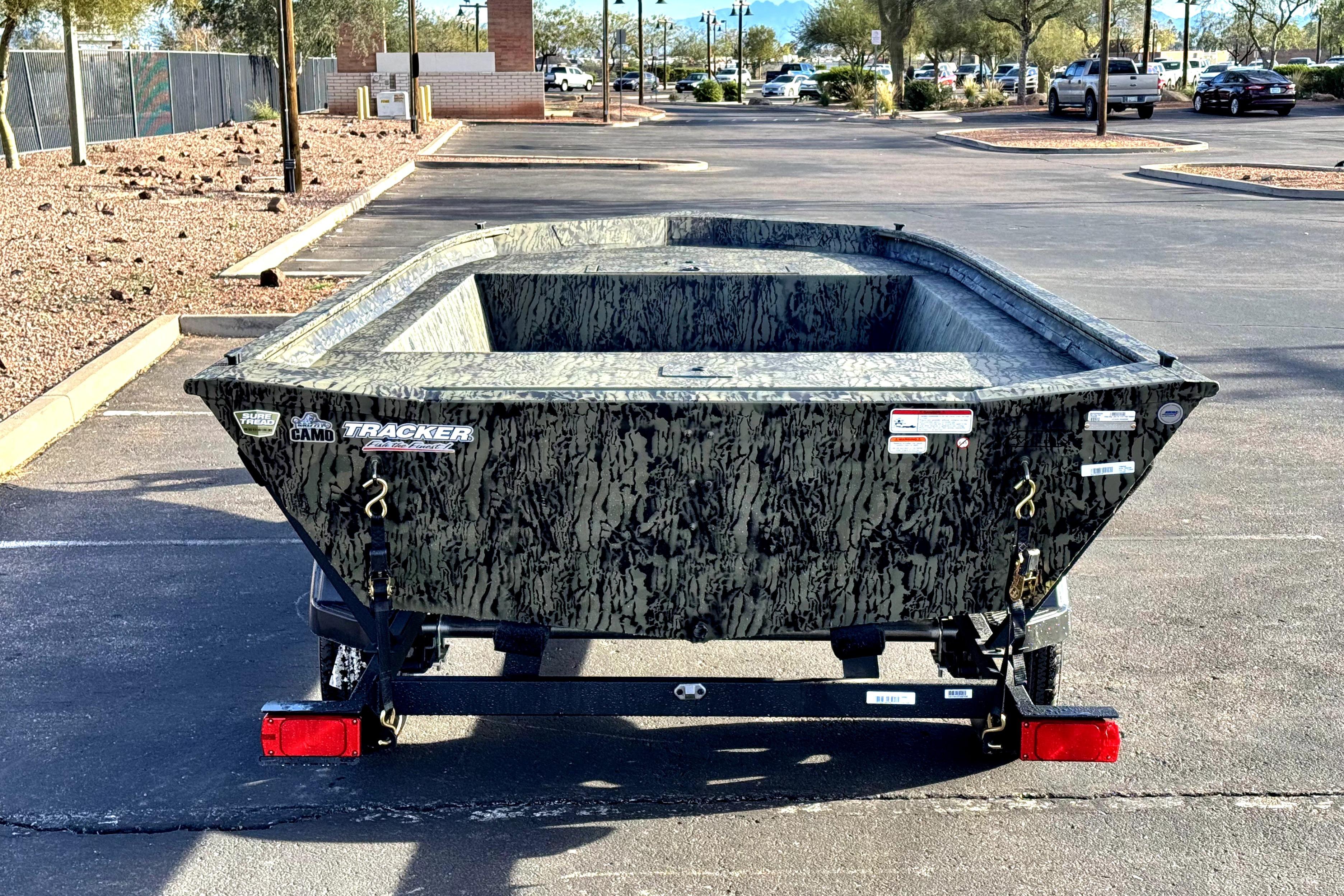 2026 Tracker Grizzly 1754 Utility boat in a parking lot, camo design.