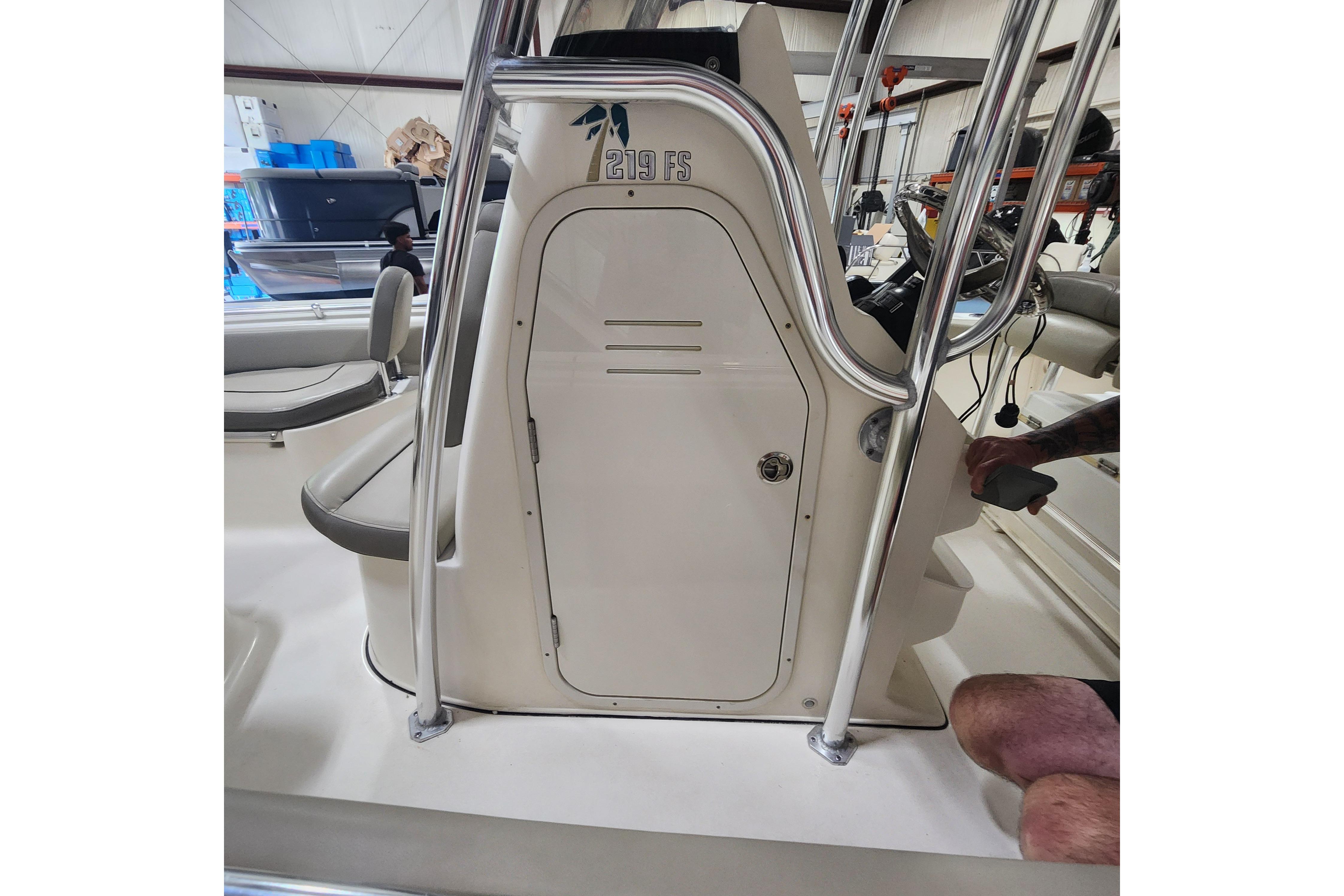 2023 Key West 219 FS boat interior with console and seating in a showroom.