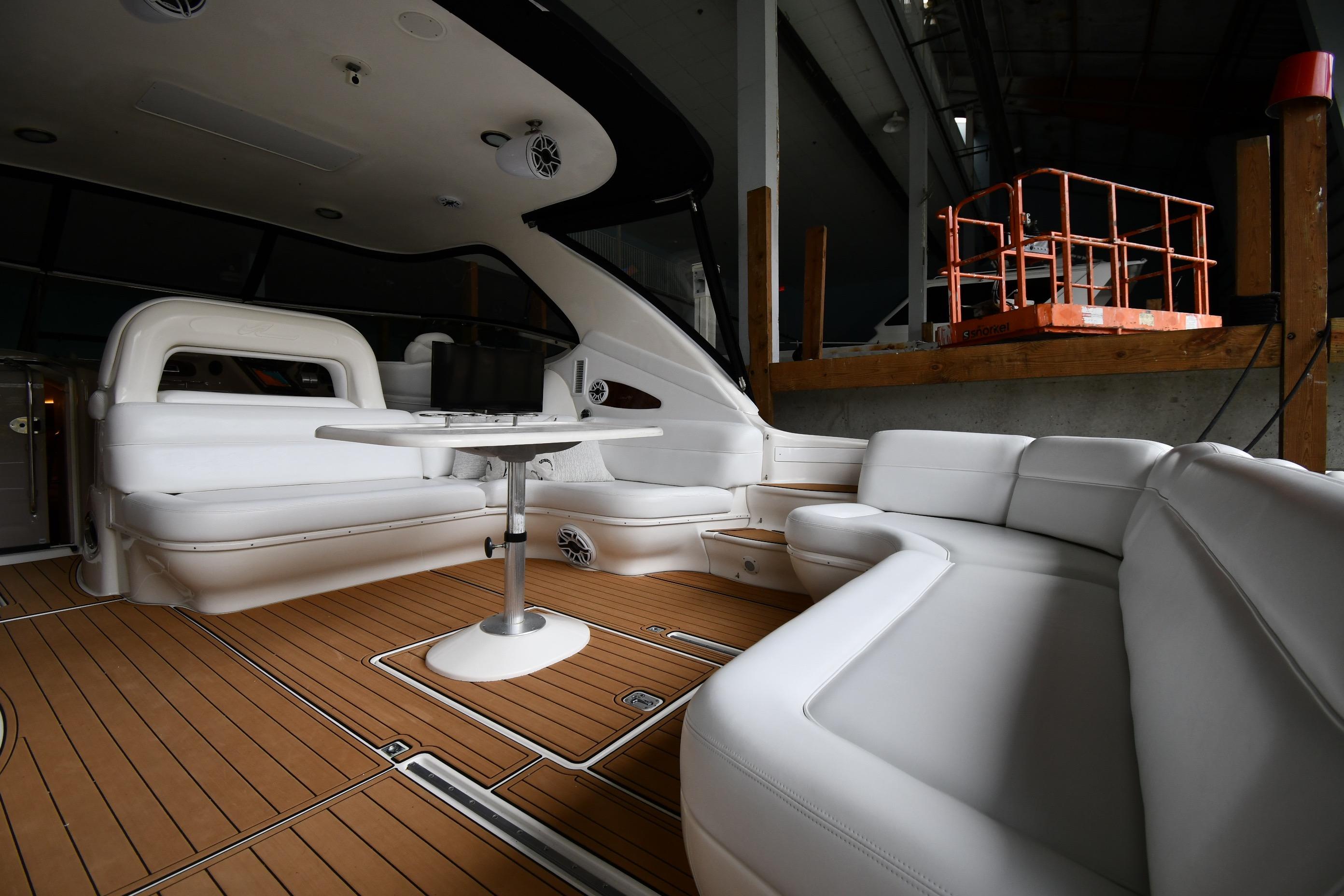 Luxurious interior of 2001 Sea Ray 540 Sundancer yacht with white seating and wooden flooring.