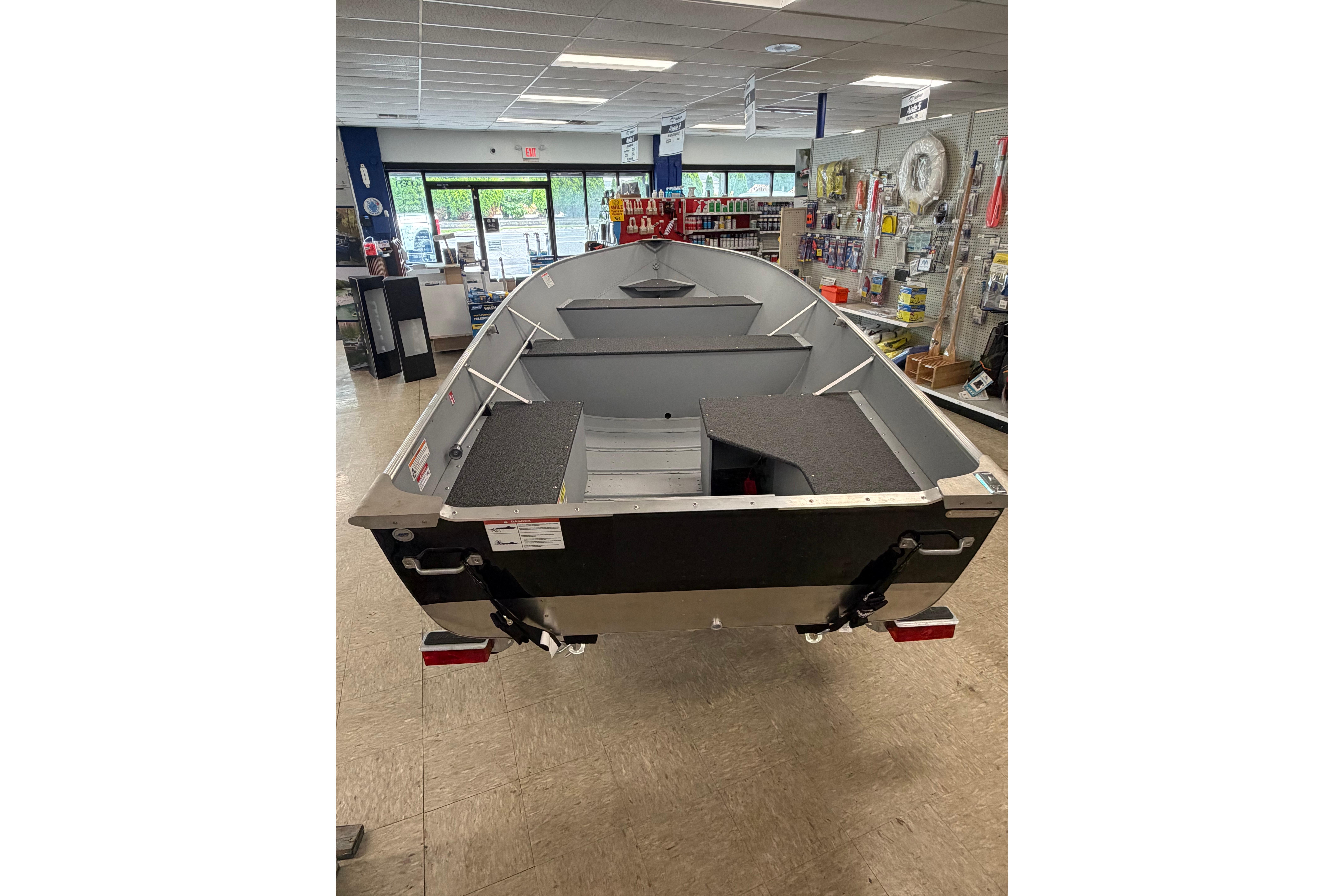 2027 Lund WC 16 boat displayed in a showroom with marine accessories.