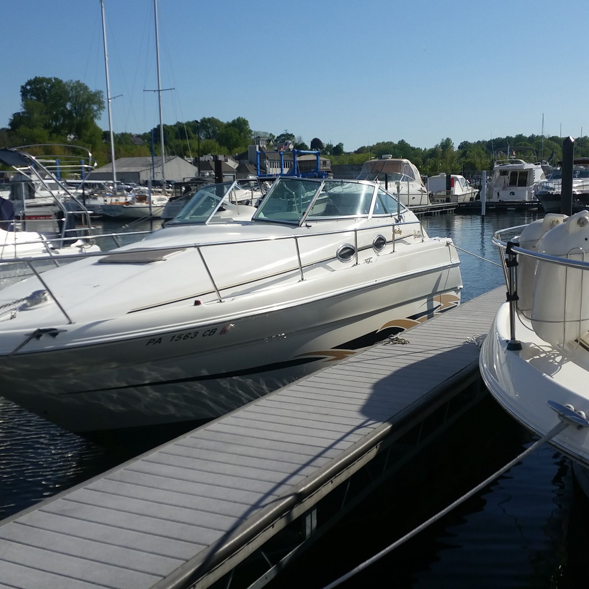 A 1998 Sea Ray 270 Sundancer docked at a marina, surrounded by other boats.