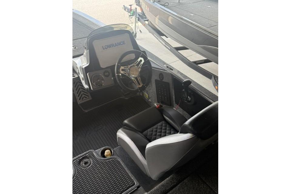 2023 Caymas CX 21 PRO boat cockpit with Lowrance display and black seating.