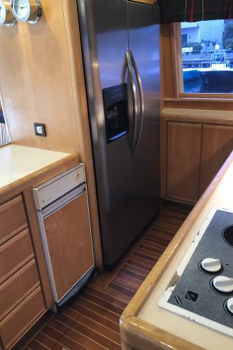 1997 Bertram Convertible kitchen with stainless steel refrigerator and wooden cabinetry.