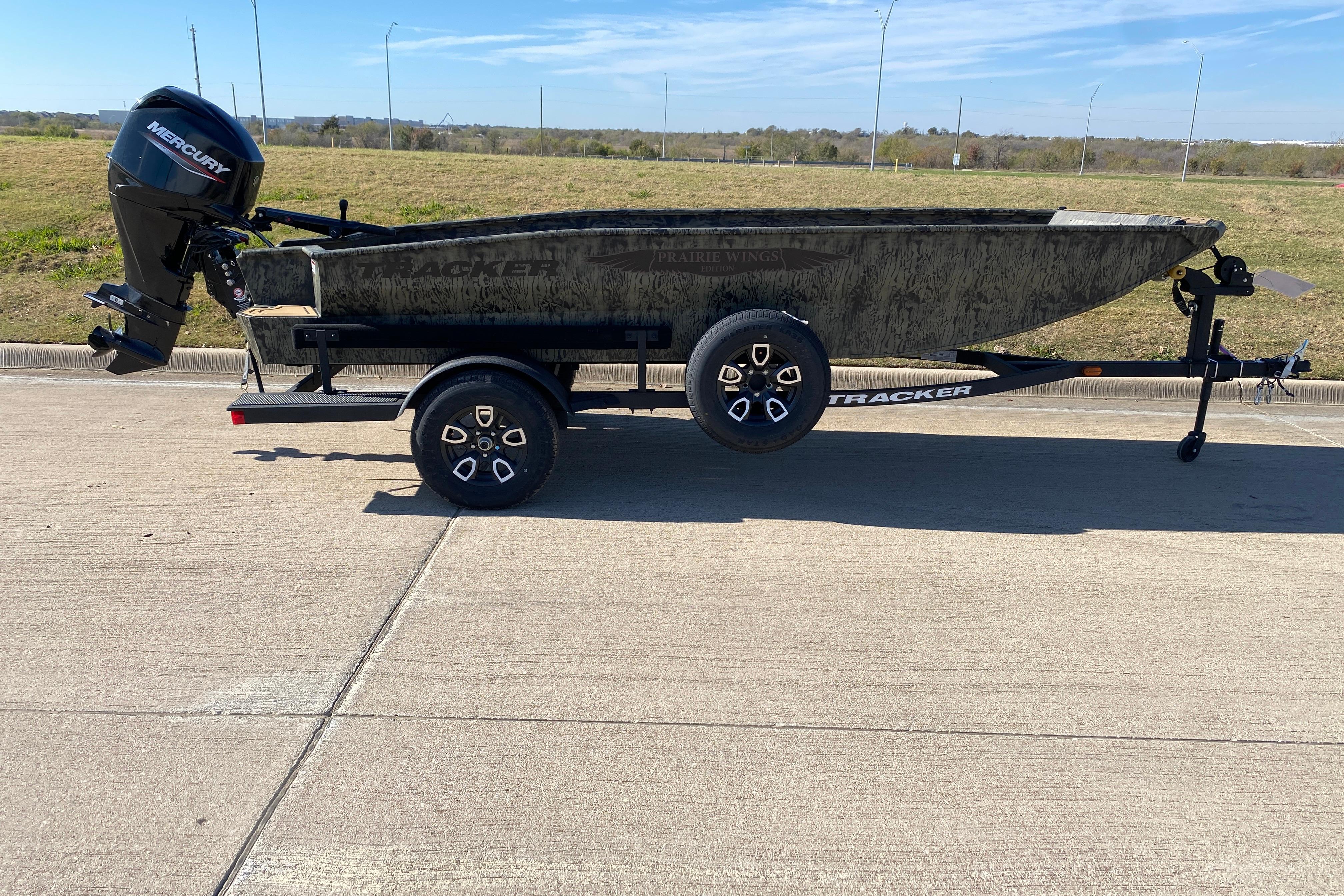 2026 Tracker Grizzly 1650 T Prairie Wings Edition boat on trailer, side view.