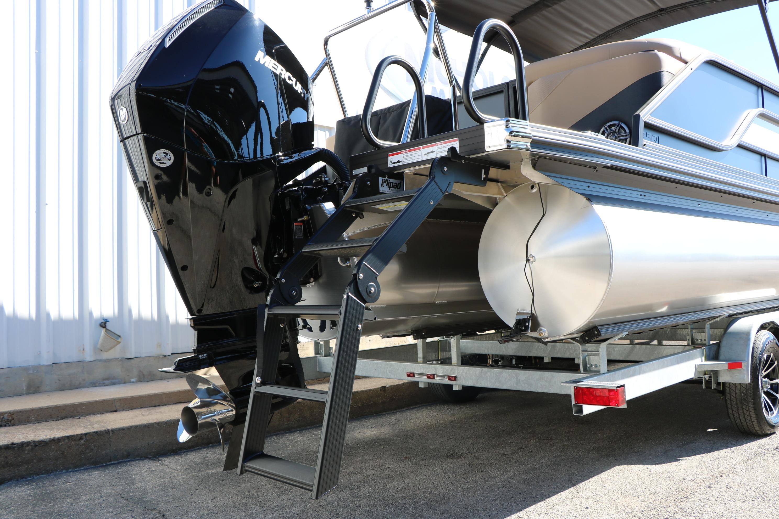 2026 Evotti 525 QL Tri-Toon boat with Mercury engine and ladder on trailer.
