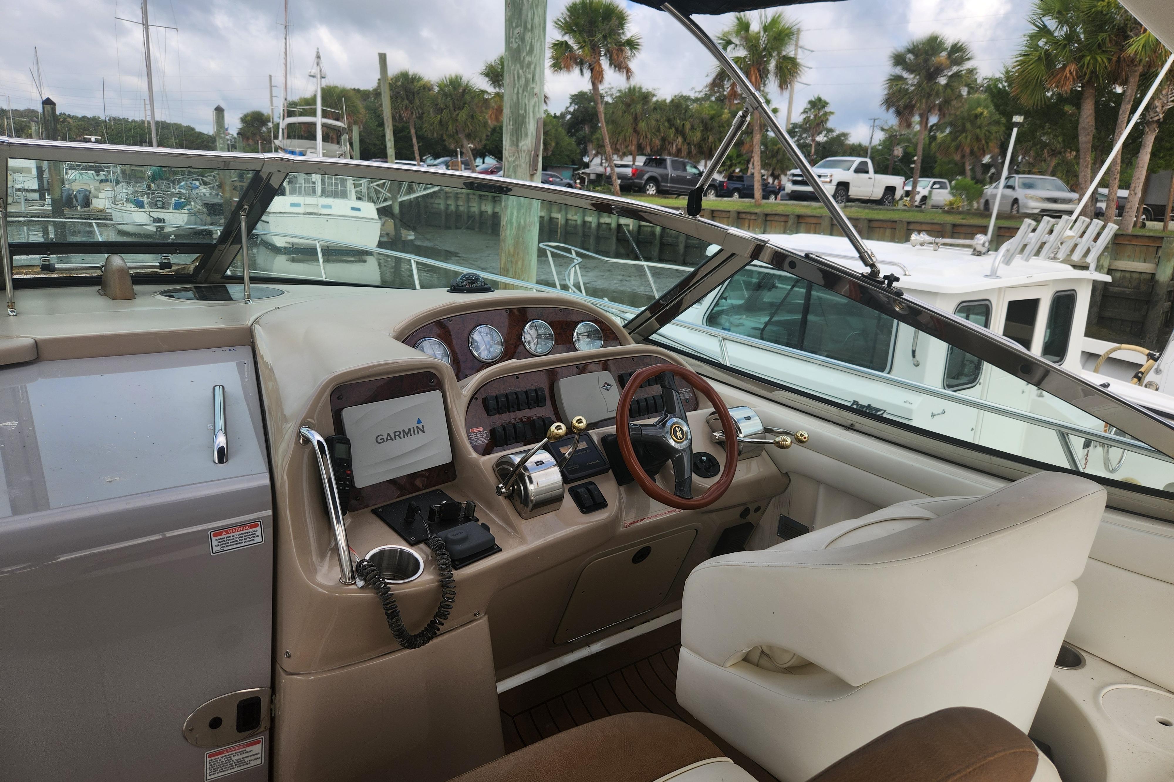Cockpit of 2003 Sea Ray 360 Sundancer with Garmin navigation, docked at marina.