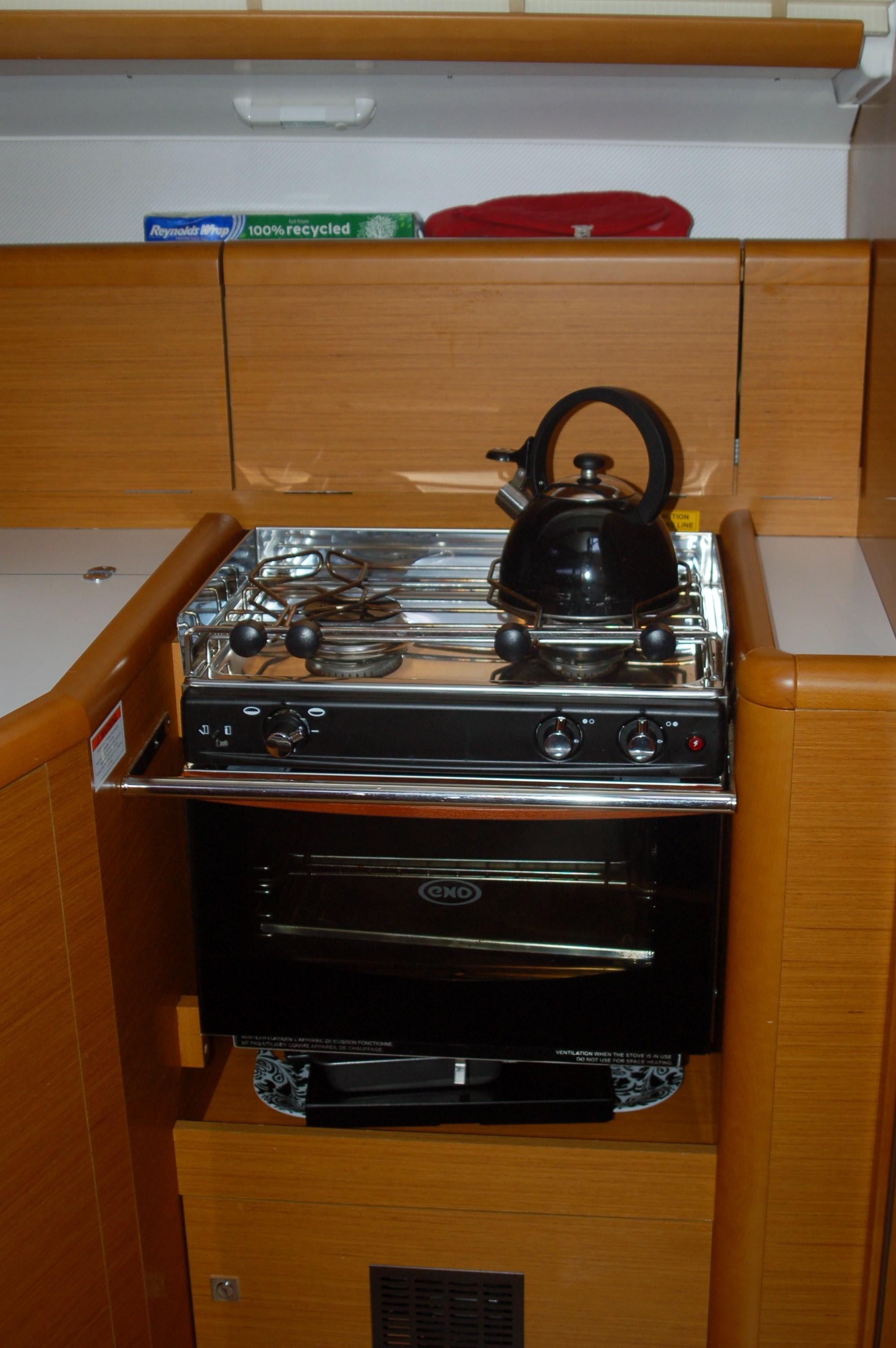 Compact kitchen in 2013 Jeanneau Sun Odyssey 33i yacht with stove and kettle.
