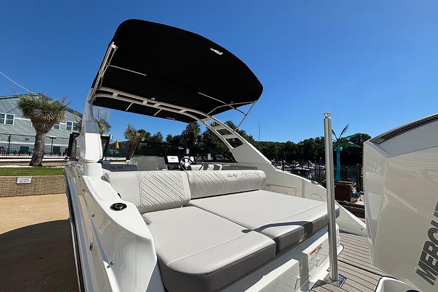 2027 Sea Ray SDX 230 Outboard boat with spacious seating and canopy under clear blue sky.