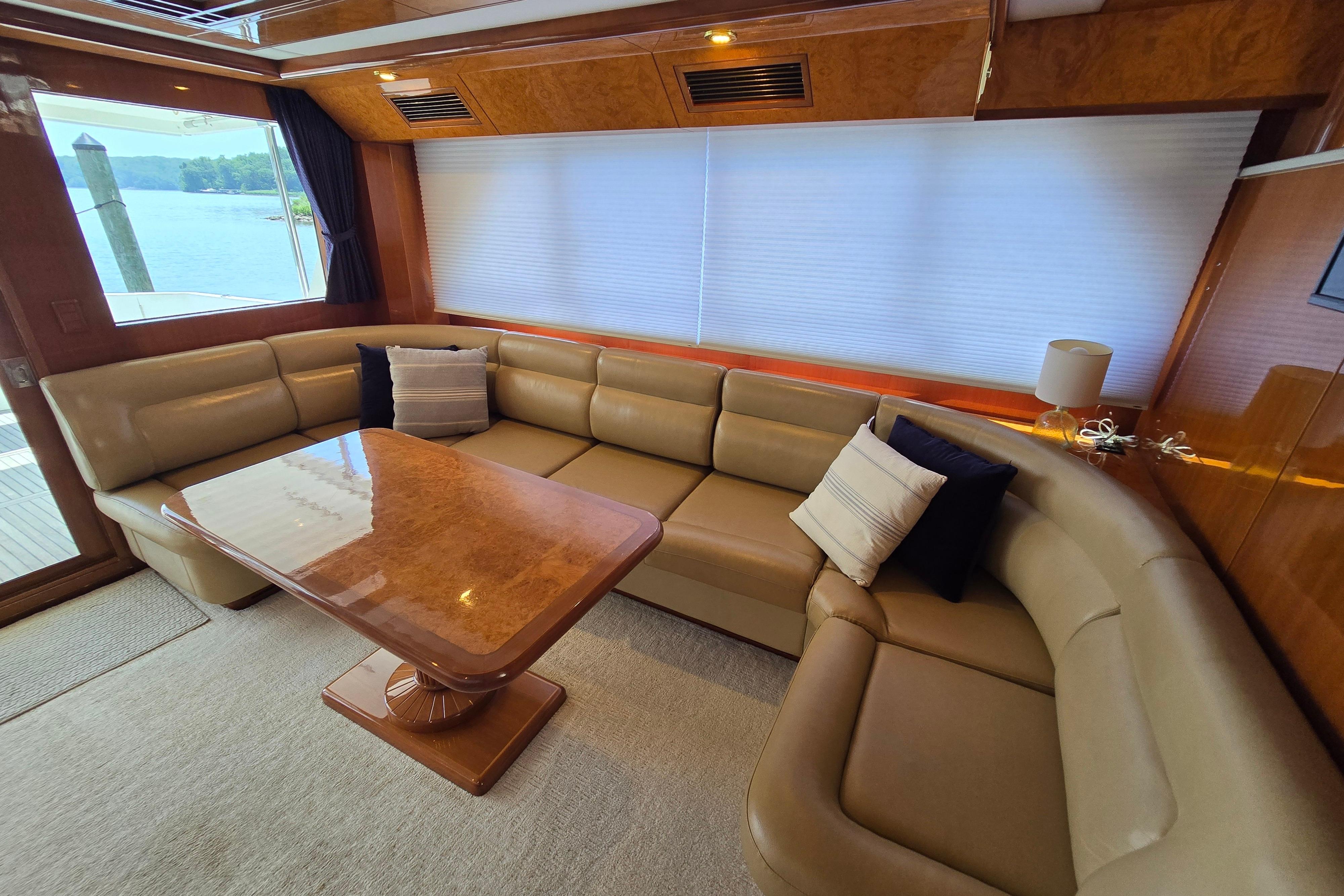 Luxurious interior of 2004 Grand Harbour 58 yacht with leather seating and wooden table.