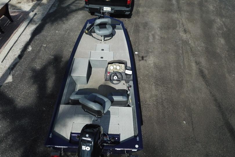 2020 Tracker Pro 170 boat with dual seats and steering console, parked on asphalt.