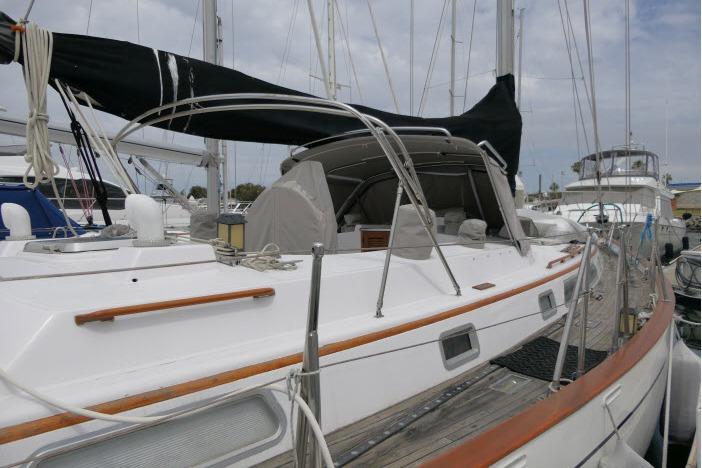 1986 Tayana 52 Center Cockpit sailboat docked at marina, featuring sleek design and spacious deck.