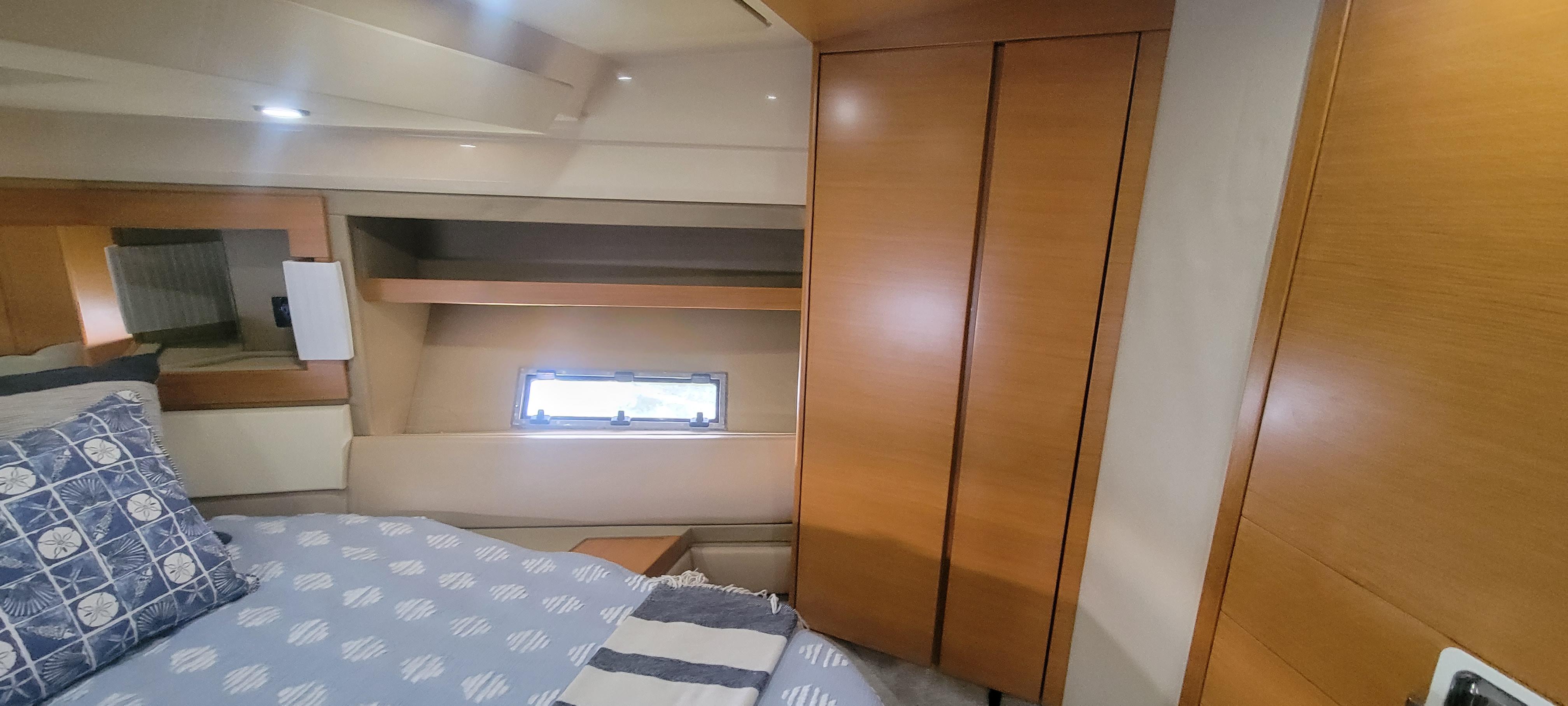 Luxurious bedroom interior of 2013 Azimut 45 Flybridge yacht with wooden cabinetry.