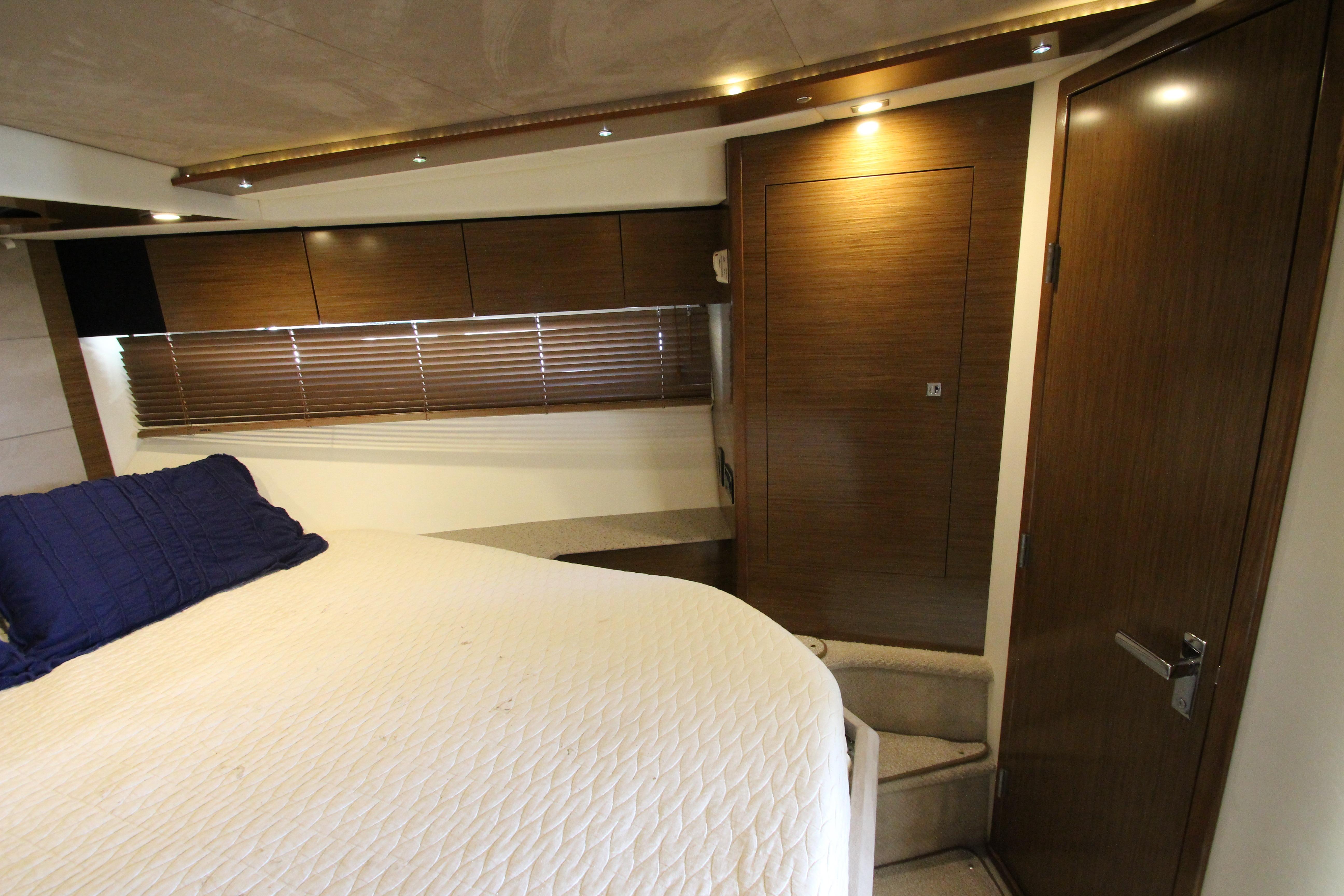 Luxurious cabin interior of 2014 Cruisers Yachts 45 Cantius with wood paneling and cozy bedding.