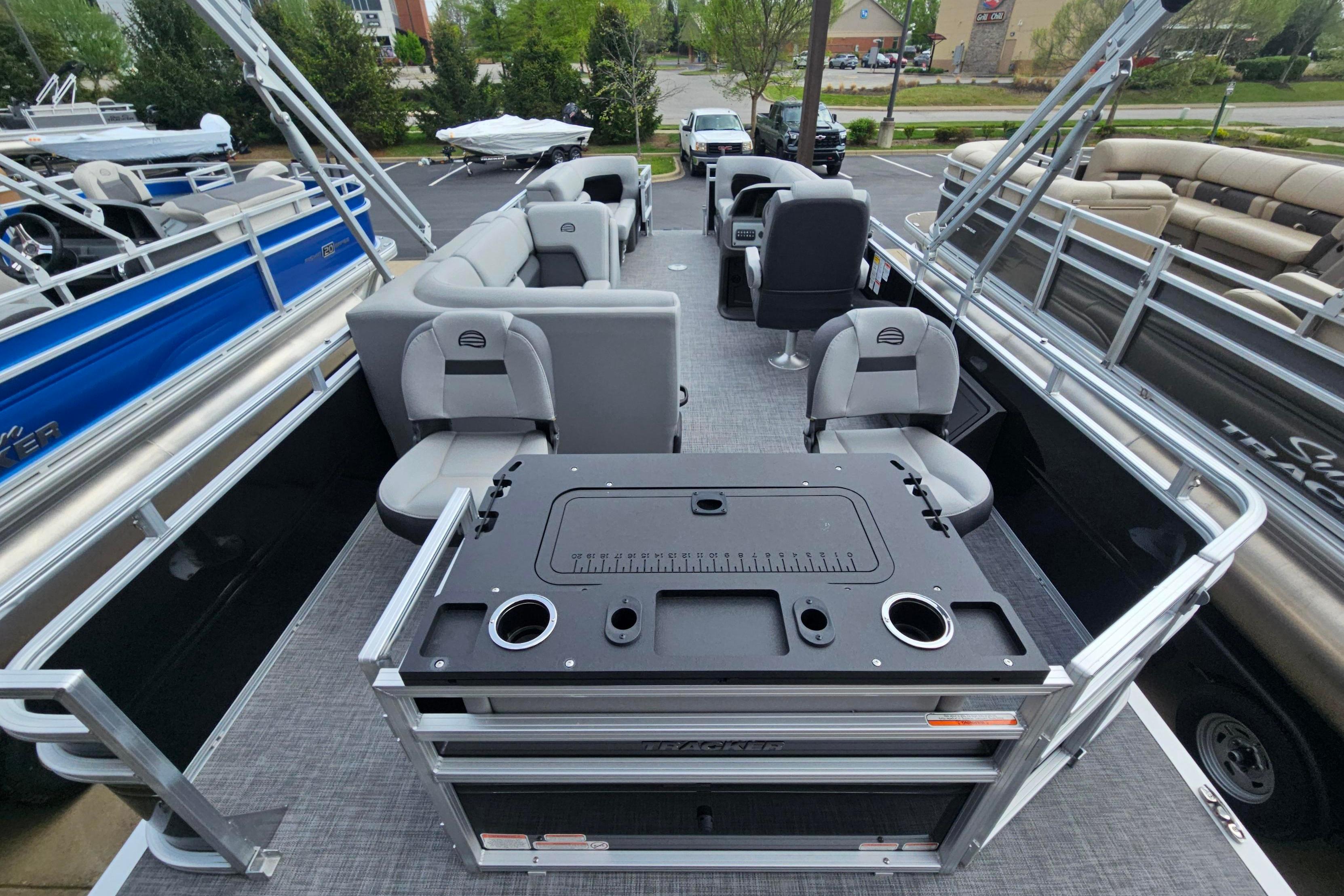 2026 Sun Tracker SportFish 22 DLX pontoon boat interior with seating and fishing station.