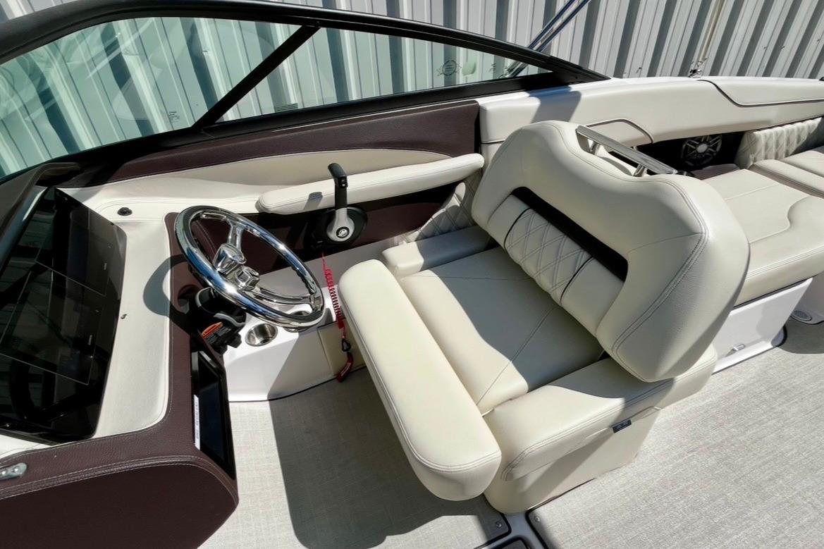 Luxurious interior of 2025 Regal LX2 boat with plush seating and sleek steering wheel.
