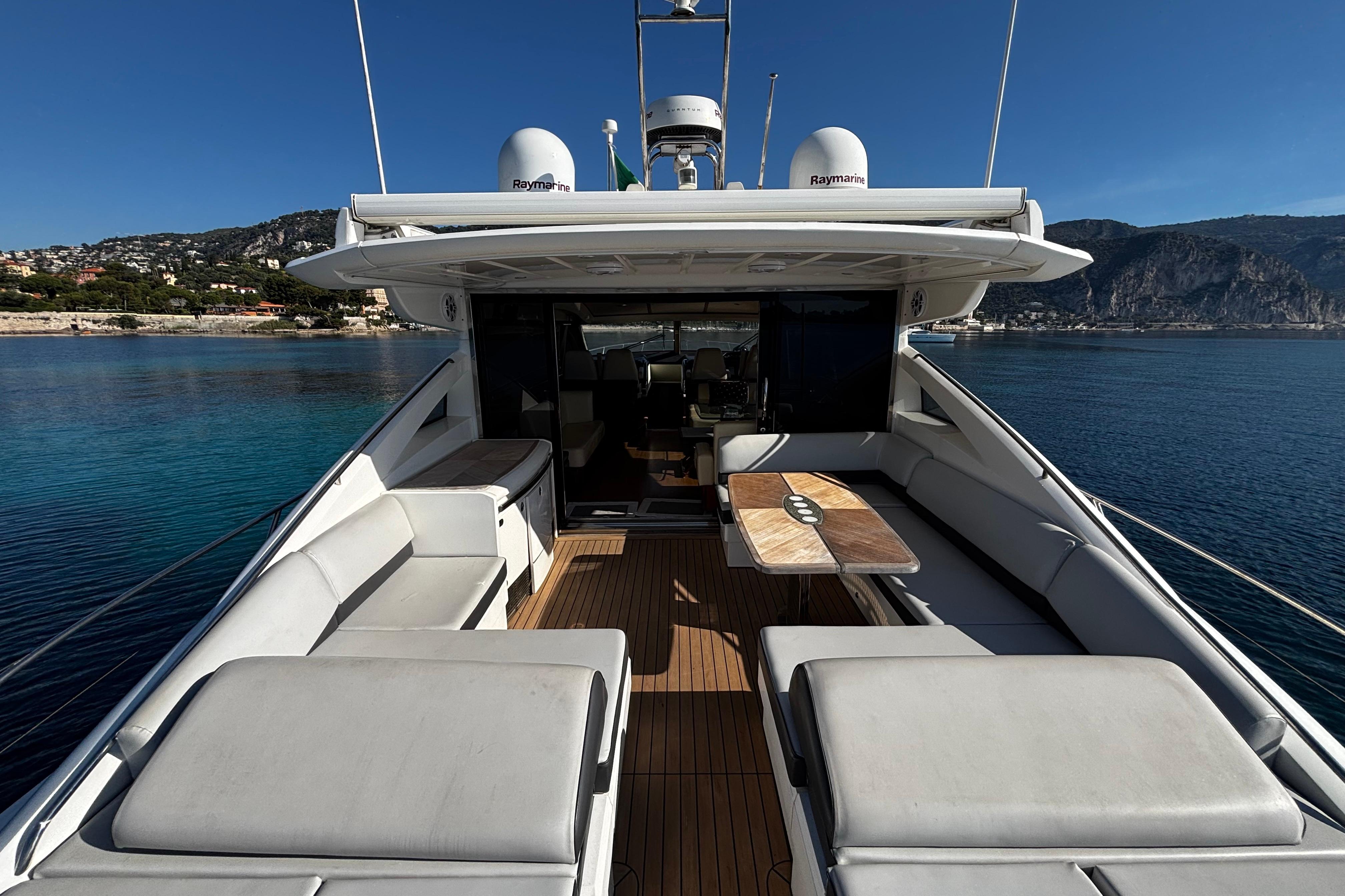 Luxurious 2006 Princess V70 yacht with spacious deck and scenic coastal backdrop.