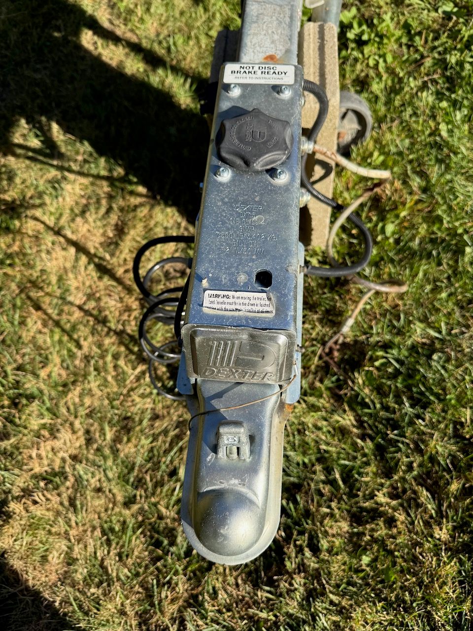 Close-up of a trailer hitch on grass.