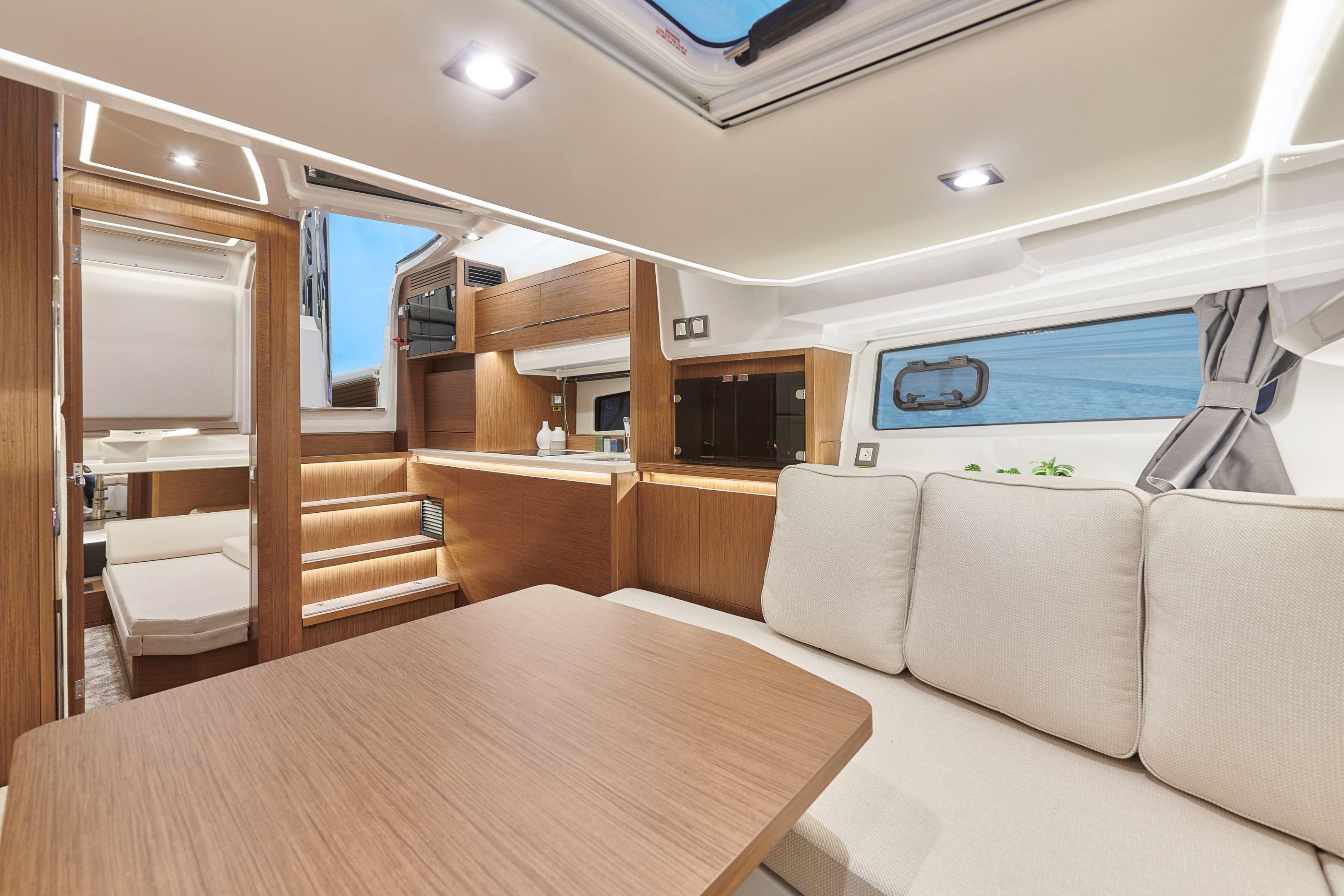 Luxurious interior of 2026 Jeanneau Leader 12.5 WA yacht with modern wood finishes.