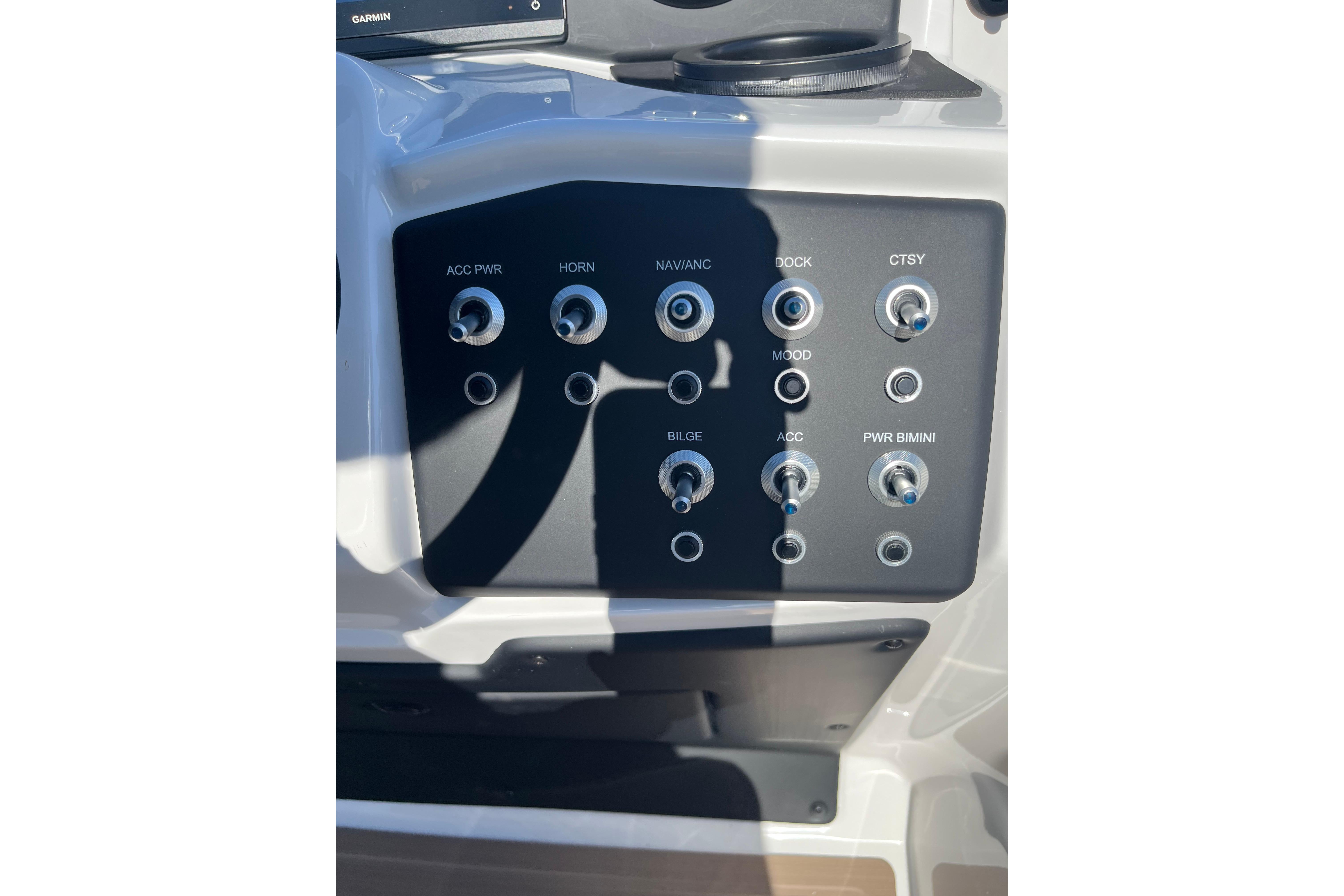 Control panel of 2026 Evotti 523CS boat with labeled switches and buttons.
