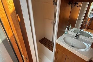 2007 Island Pilot 395 yacht bathroom with shower, sink, and wooden accents.