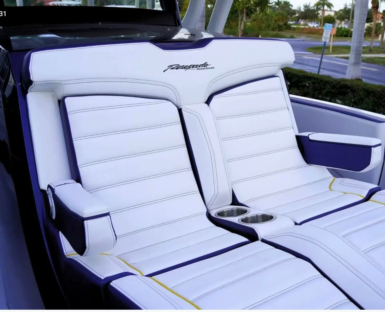The image shows luxurious white and blue boat seats with cup holders.