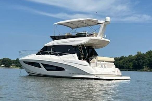 2021 Regal 42 Fly yacht on calm water under a clear blue sky.