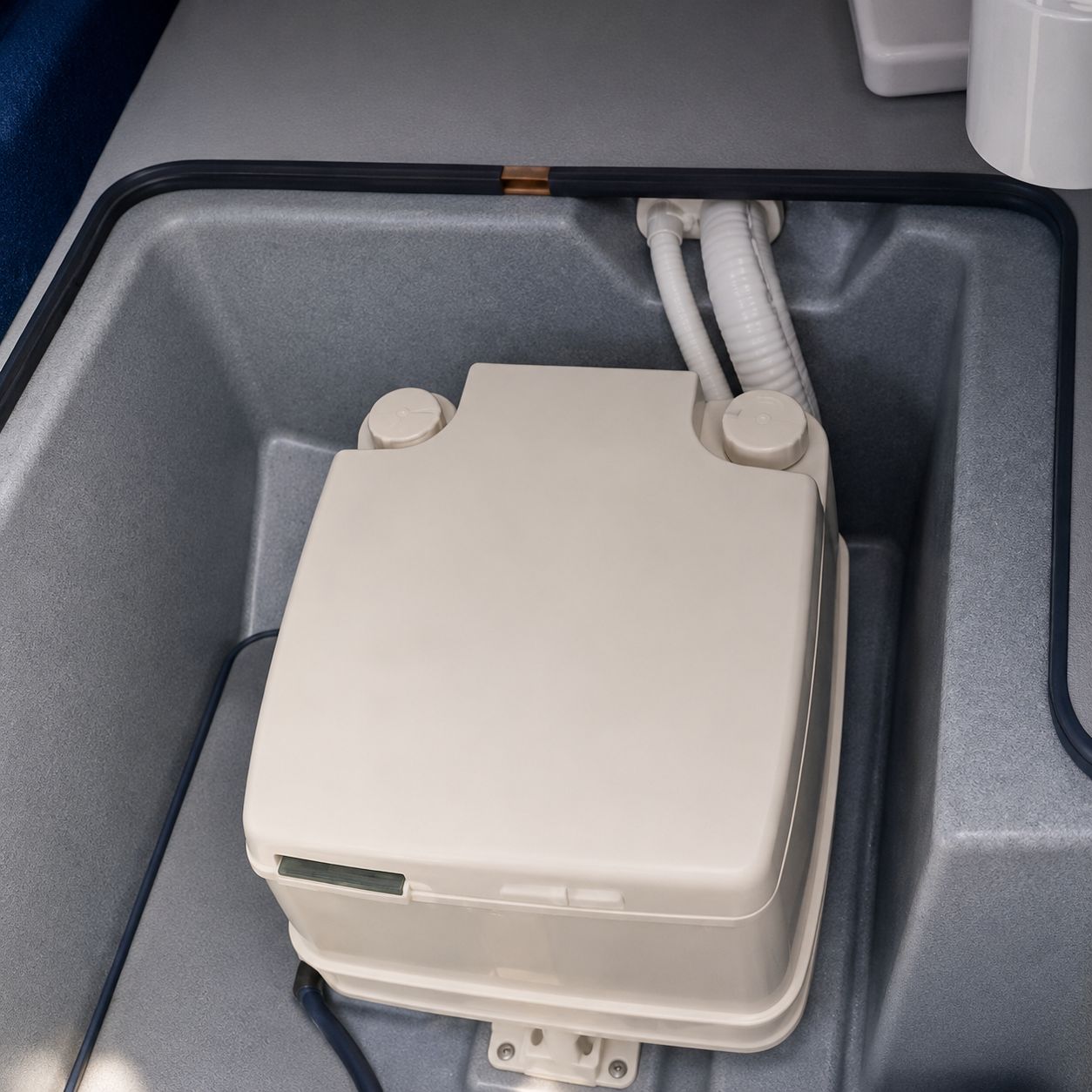 A white boat accessory is installed in a gray compartment.