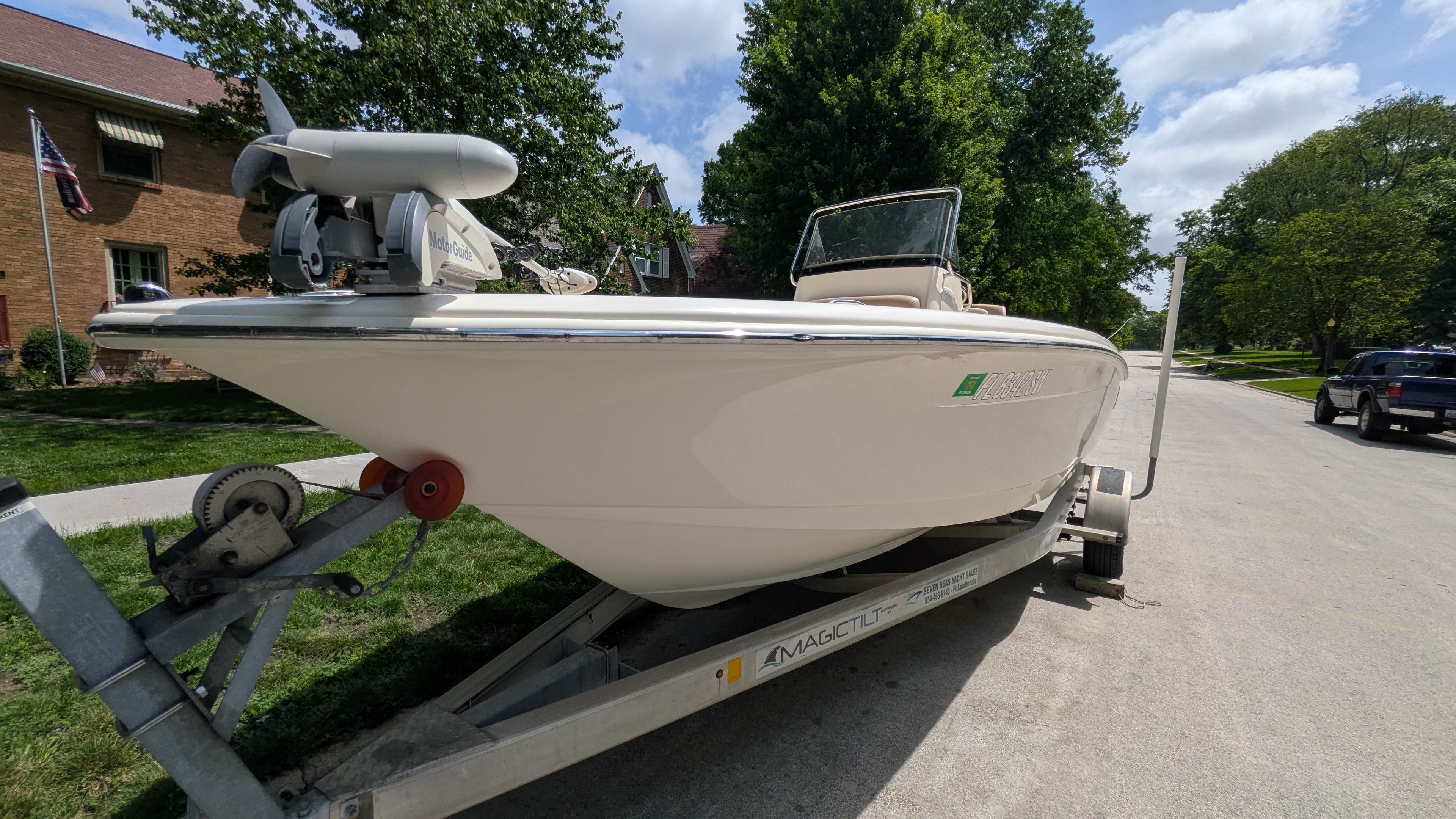 A 2021 Scout 195 Sportfish boat on a trailer in a residential area.